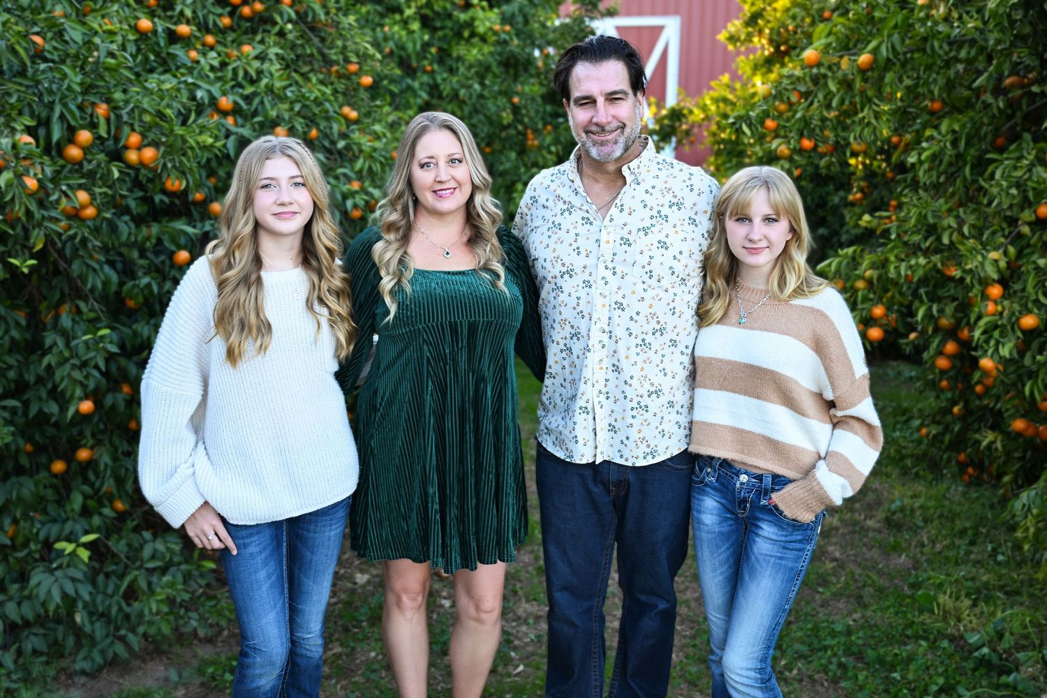 Family in front of a red barn in a citrus grove in Queen Creek Arizona