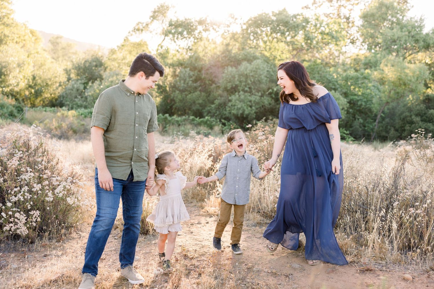 Family walking holding hands in a large field at golden hour Tempe Arizona