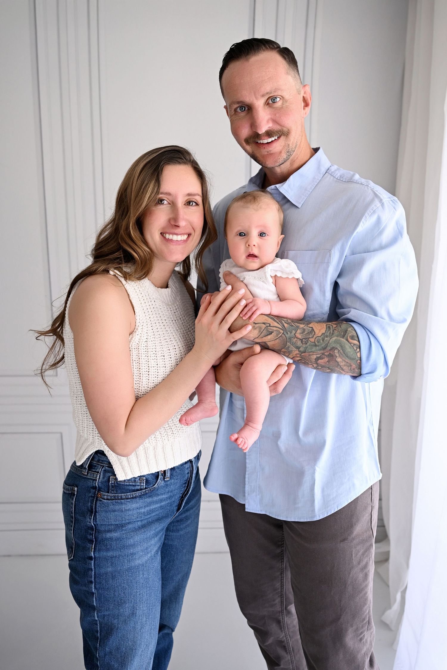 Parents hold new baby closely in their home for natural newborn session
