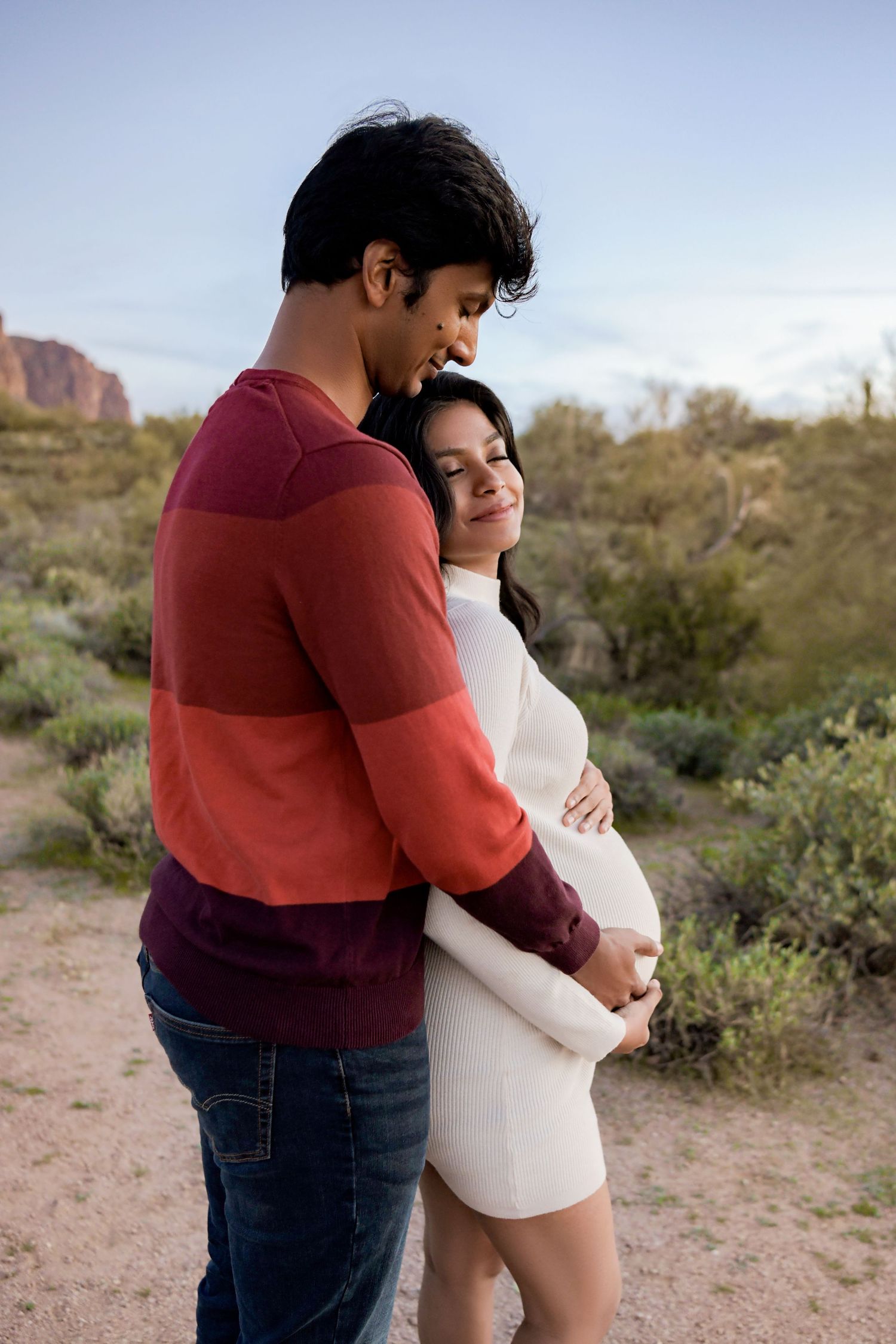 Mom and dad leaning in for a cuddle in scenic  Arizona scenery for a Maternity portrait
