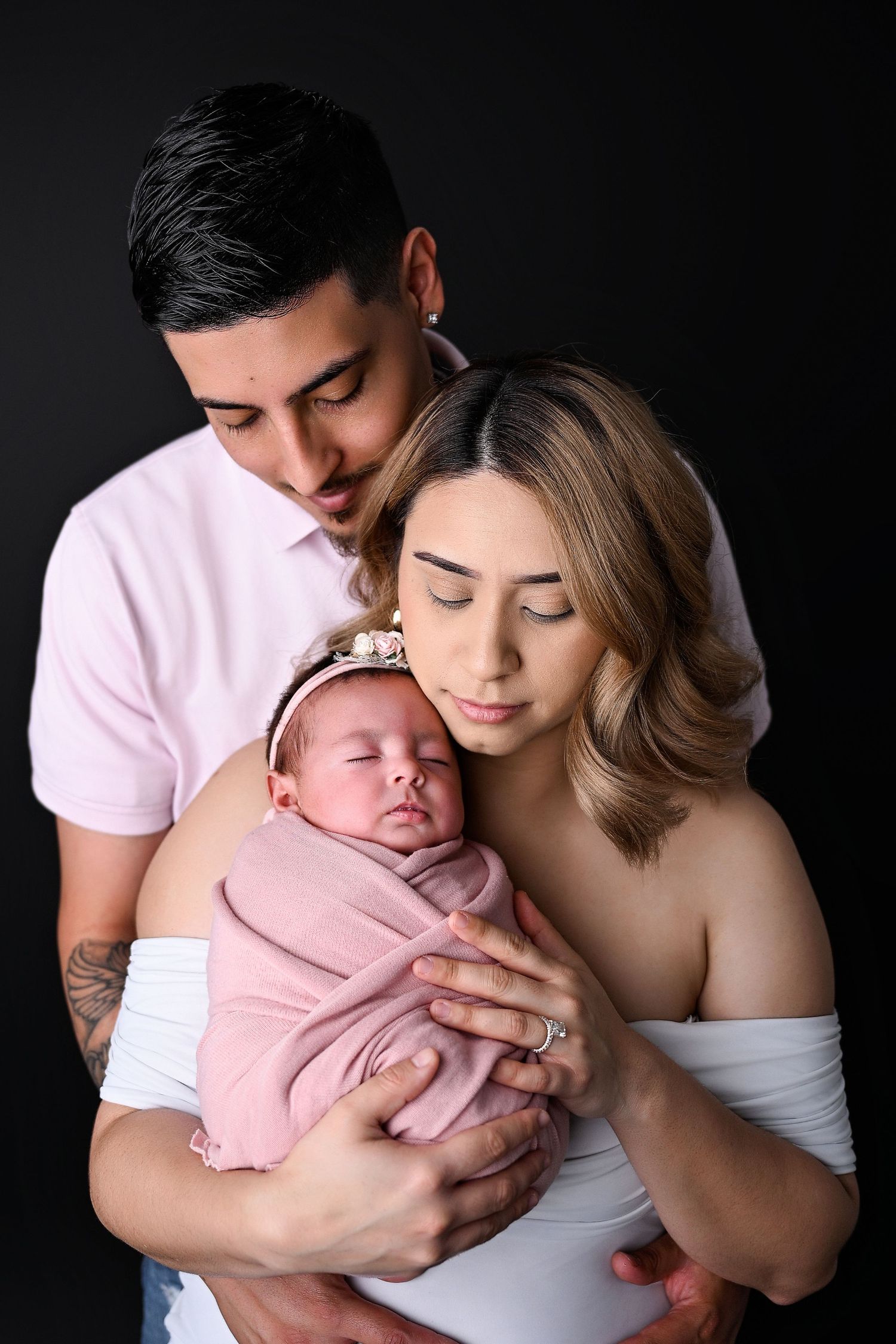Mother and Father standing holding new baby girl together