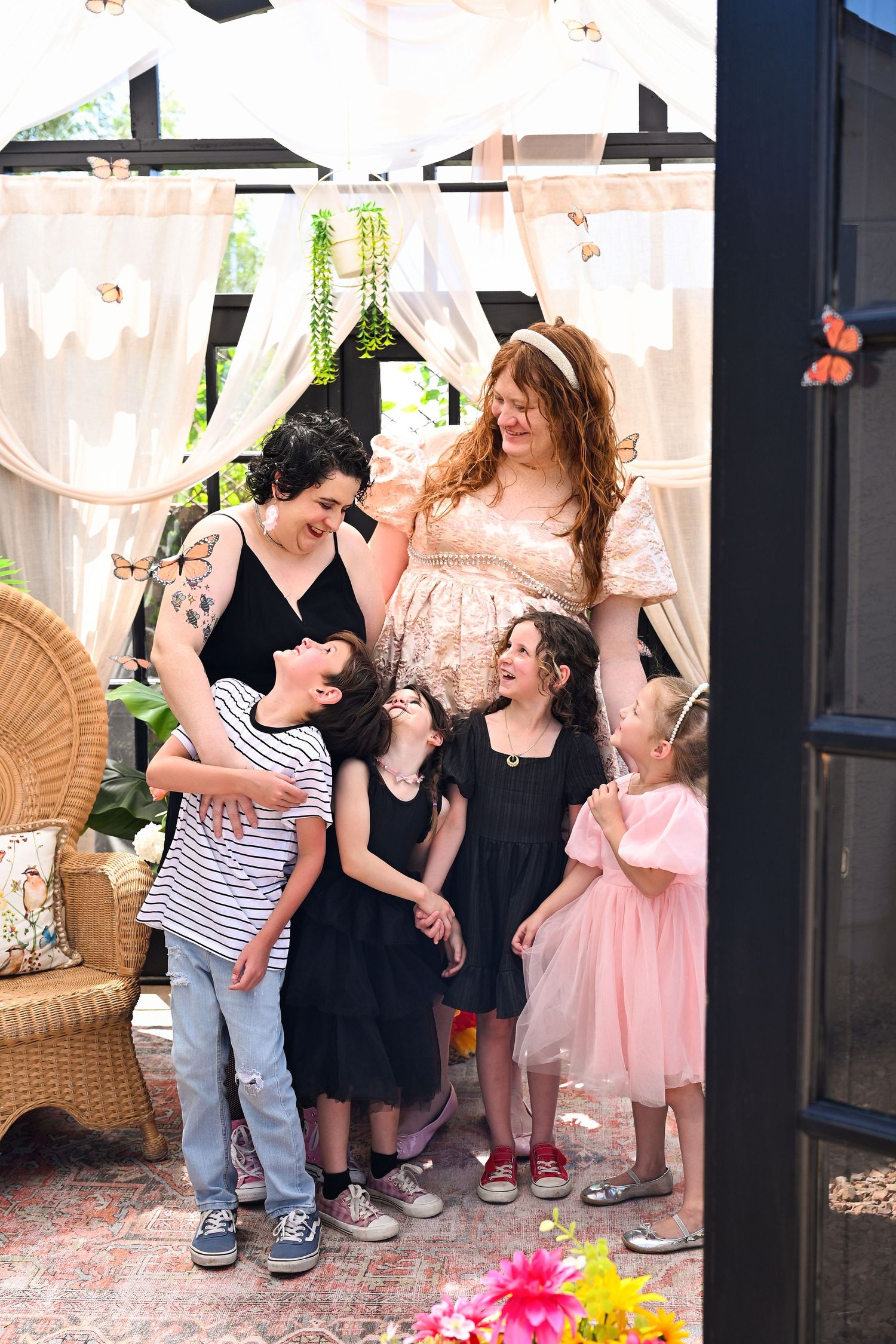 Family portrait with a bright sunny spring time greenhouse and butterflies