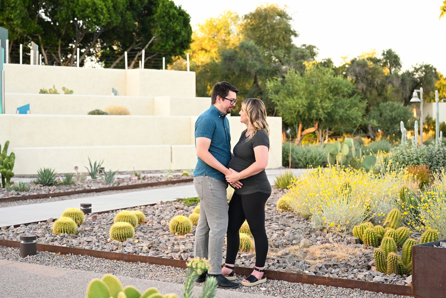 Couple standing in a park hugging surrounded by Cacti in a Scottsdale Park