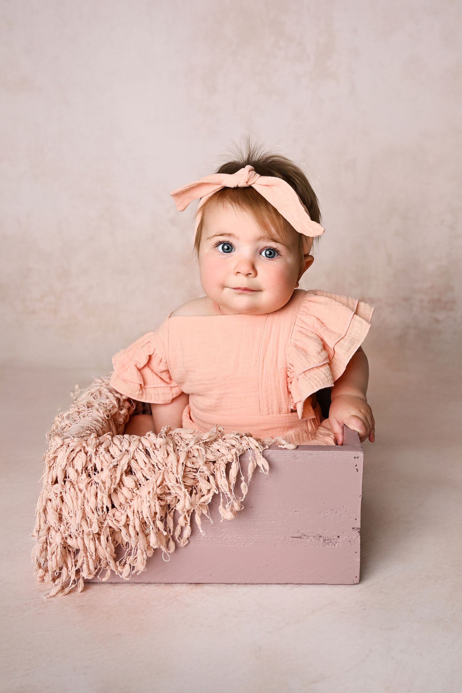 monotone pink photoshoot of baby sitting in box for Phoenix AZ Studio Milestone Six Month Sitter Photoshoot session Arizona