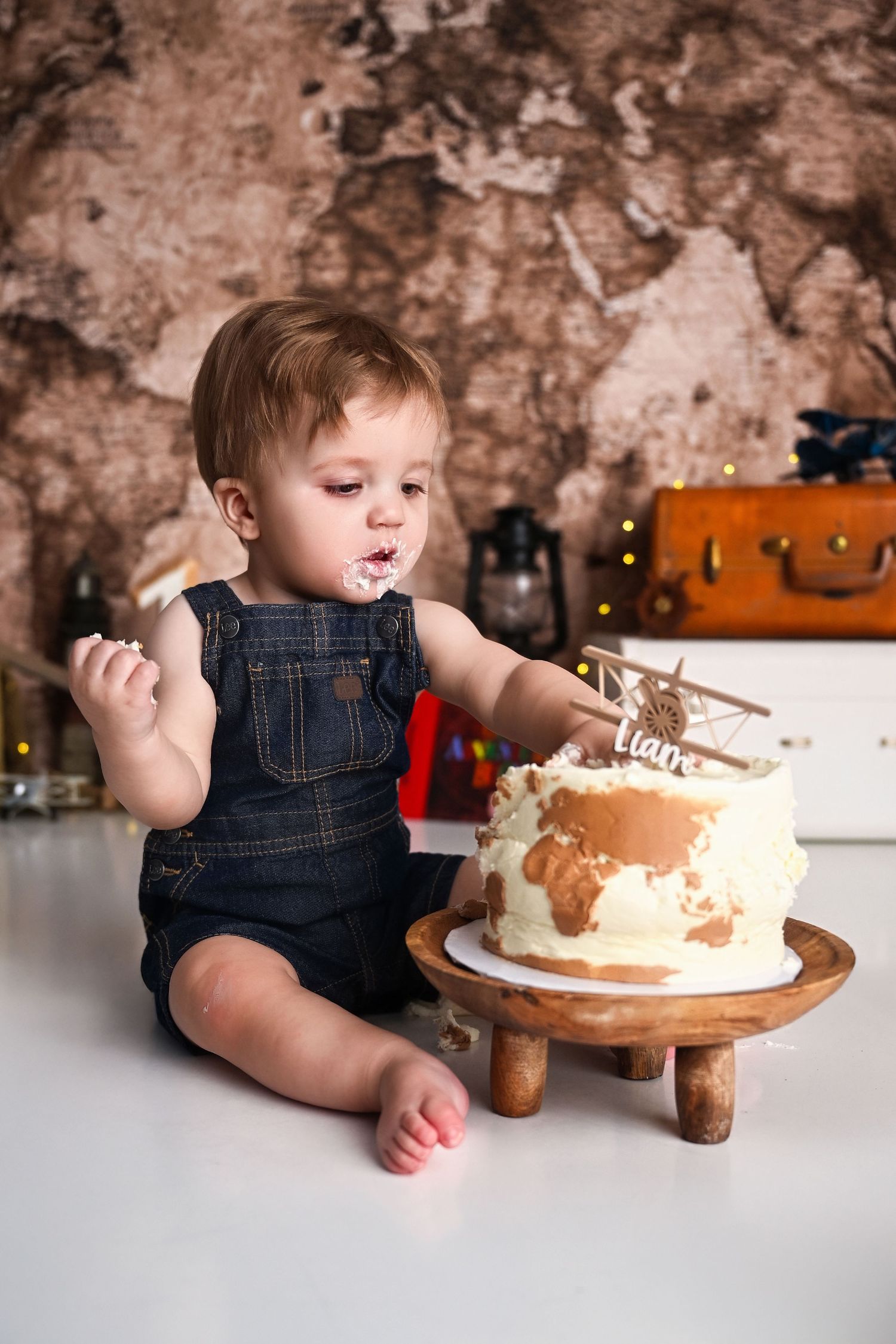 Little boy eating his cake for a travel themed cake smash session