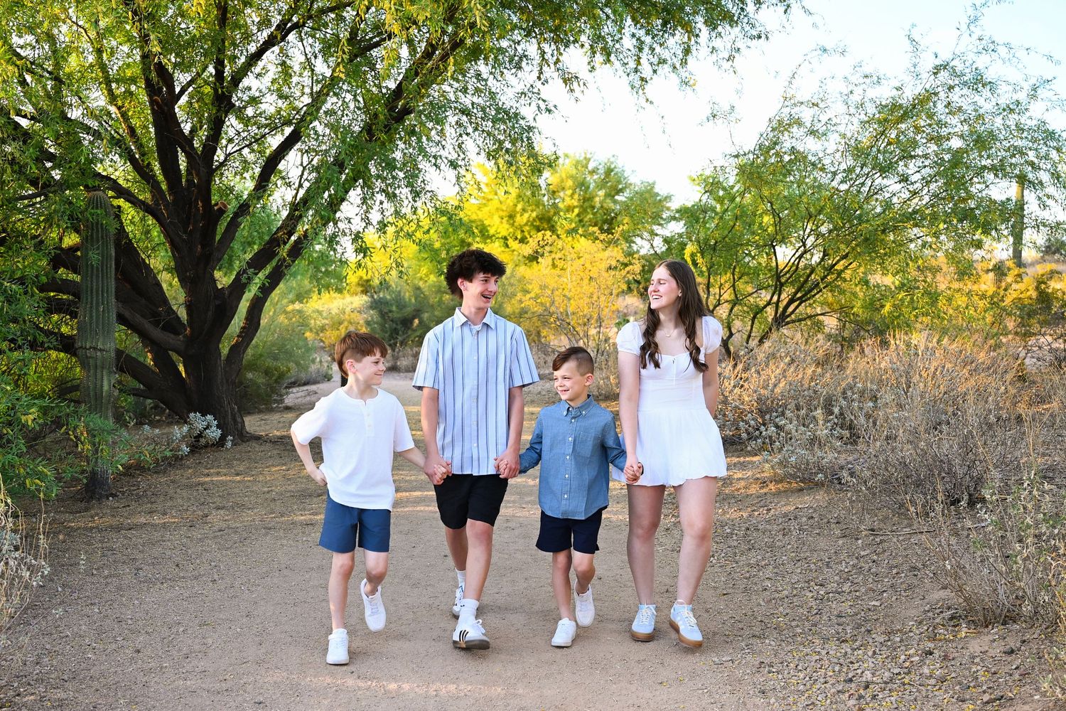 Cousins hold hands walking through Scottsdale park