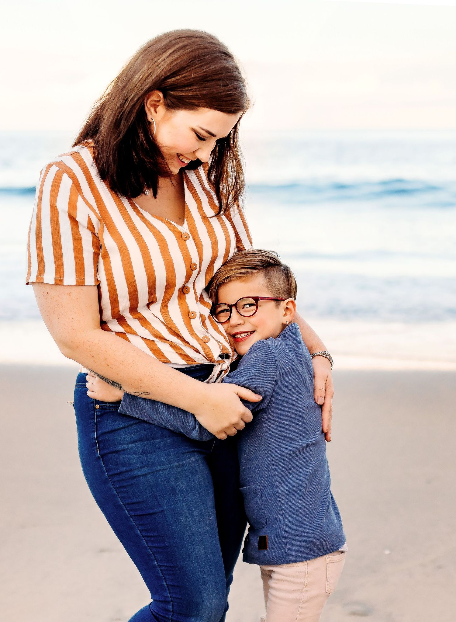 Mother and son hug each other on the beach