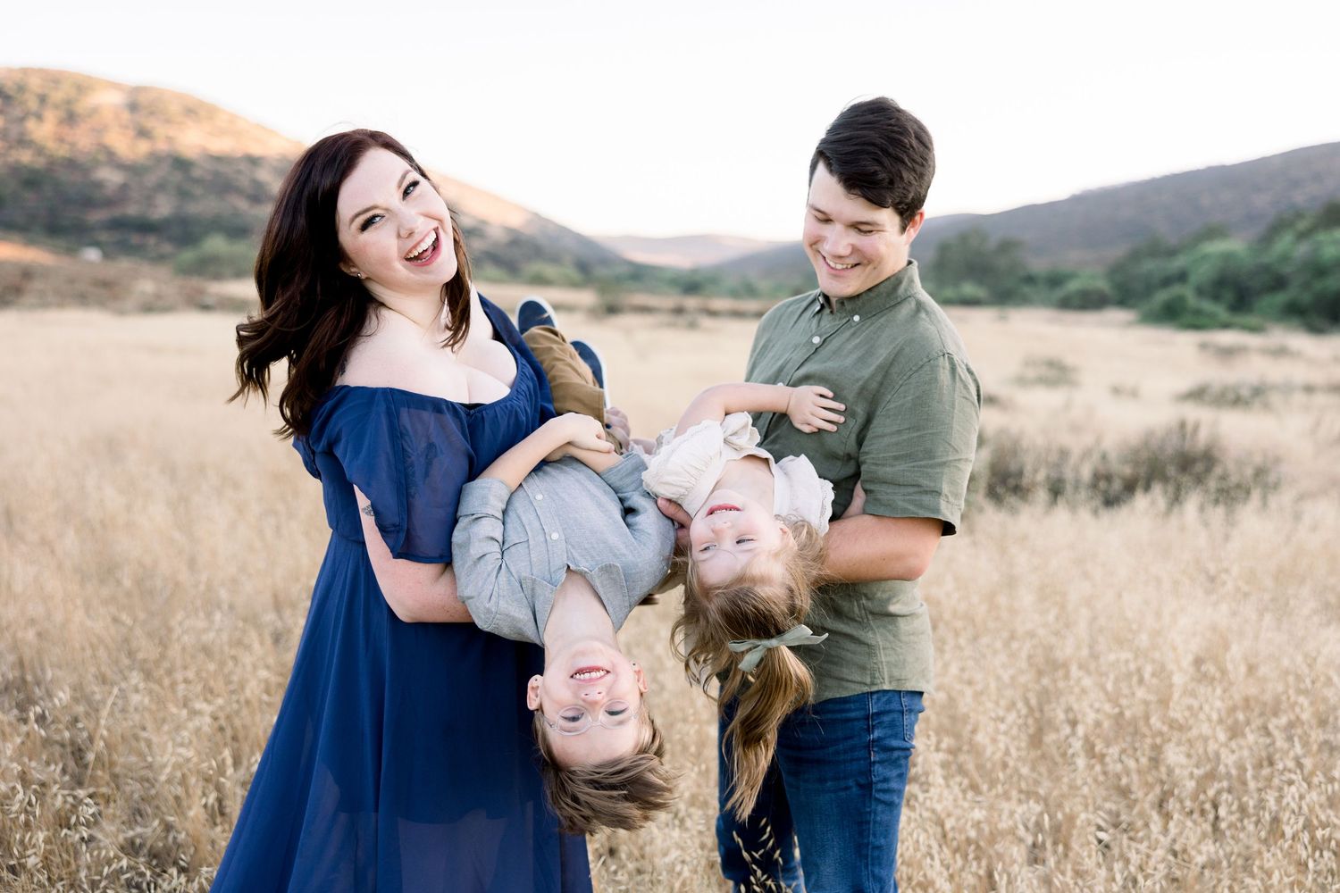 family playing candidly in large field arizona