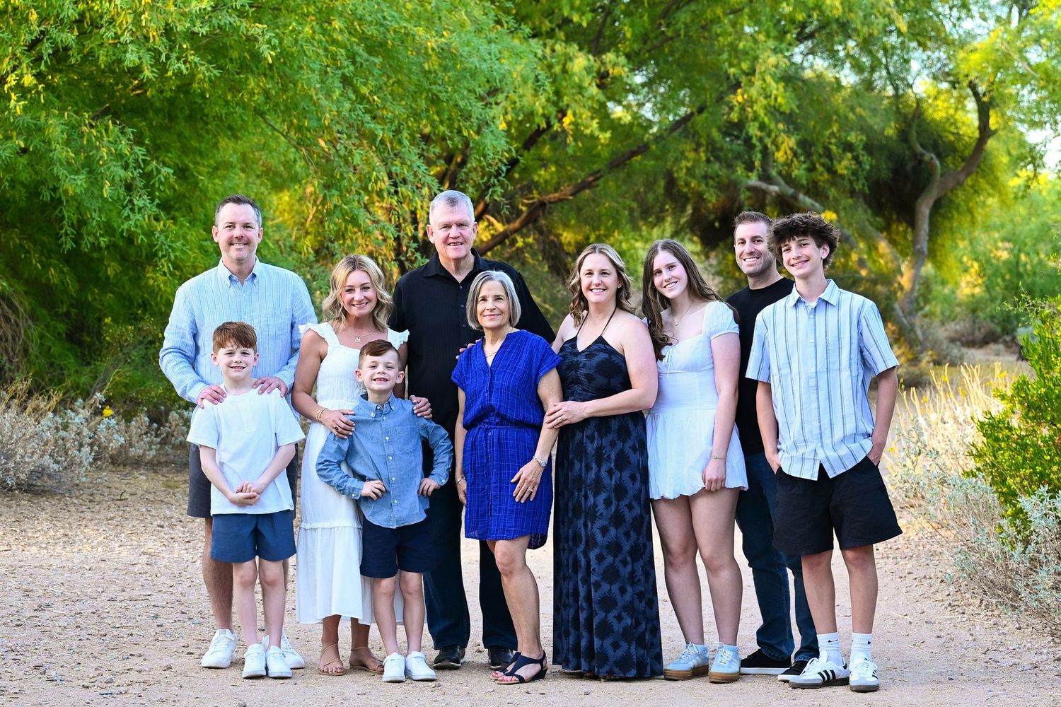 Large extended family laughing together in an autumn forest.
