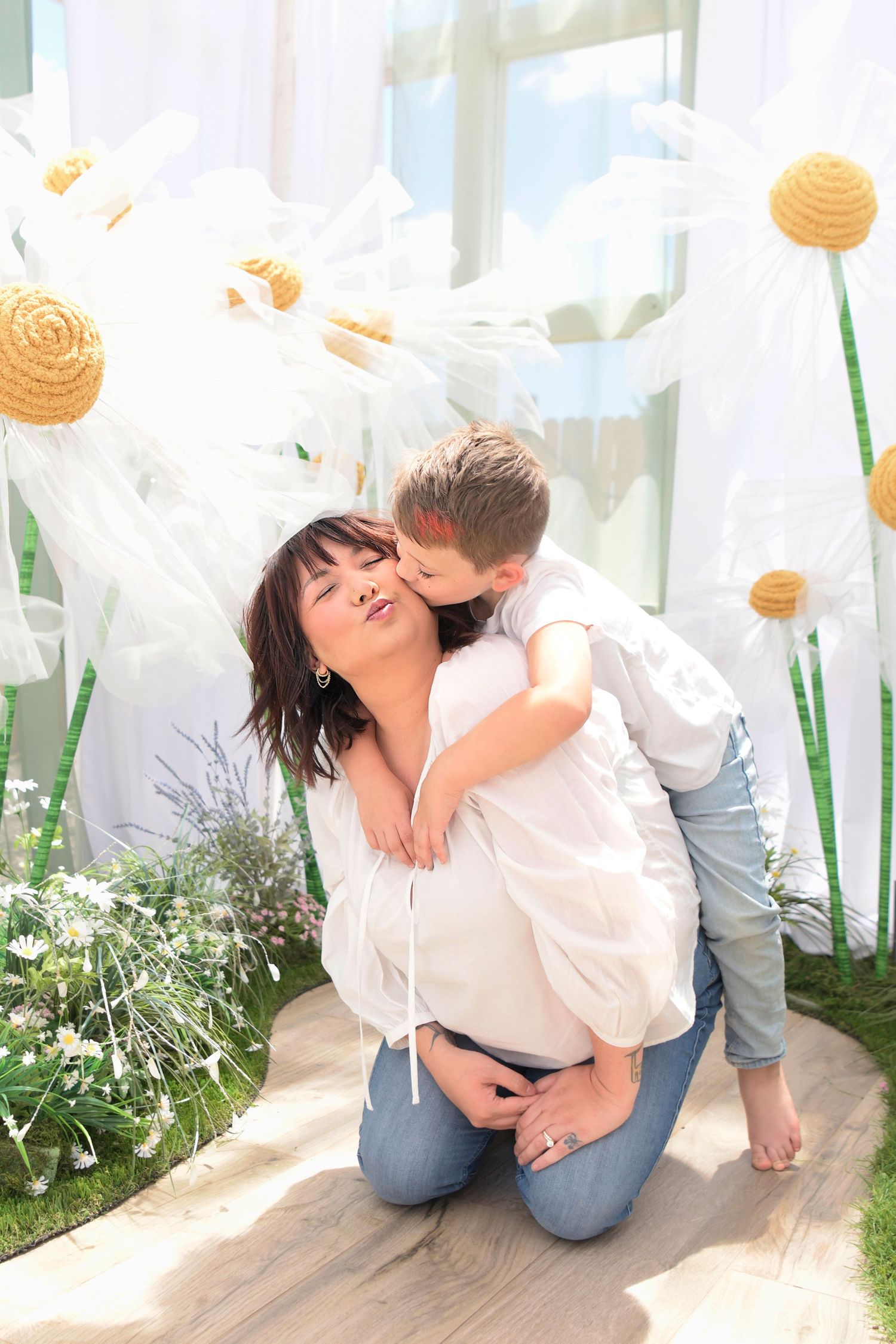 Sun kisses Mom's cheek for Mother's Day in soft light morning greenhouse surrounded by white florals