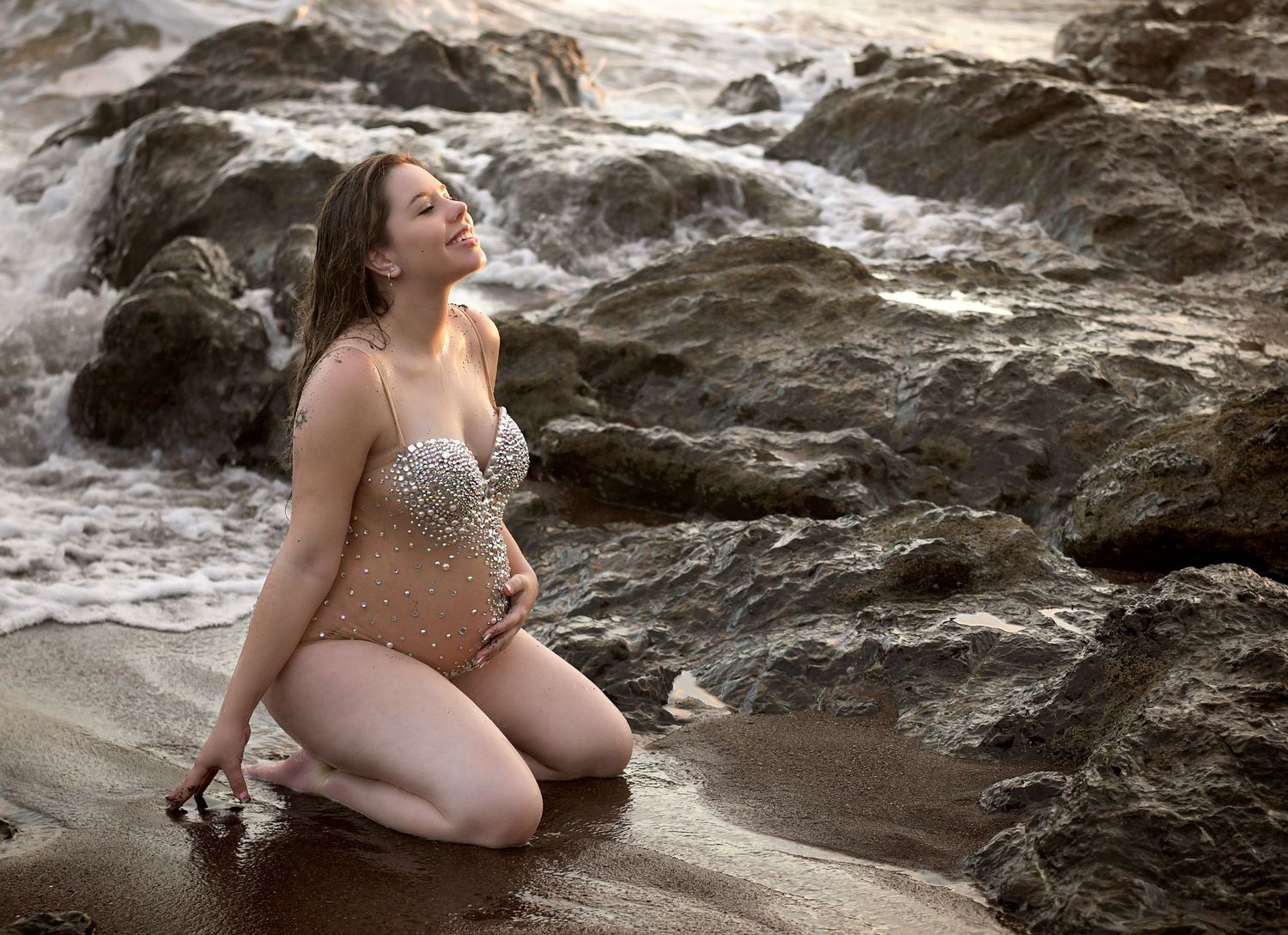 Candid maternity moment beside a calming water feature.