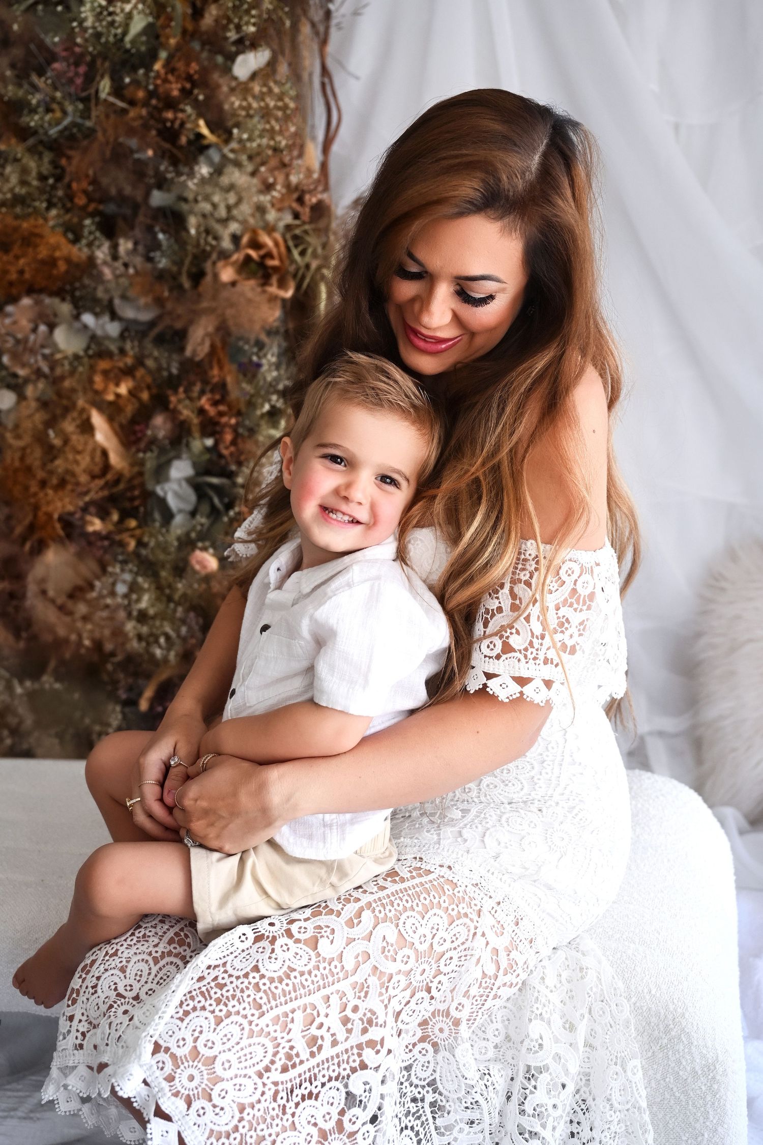 A Mother and Son cuddled up in a Phoenix Photography studio for Boho Mommy and Me pictures.