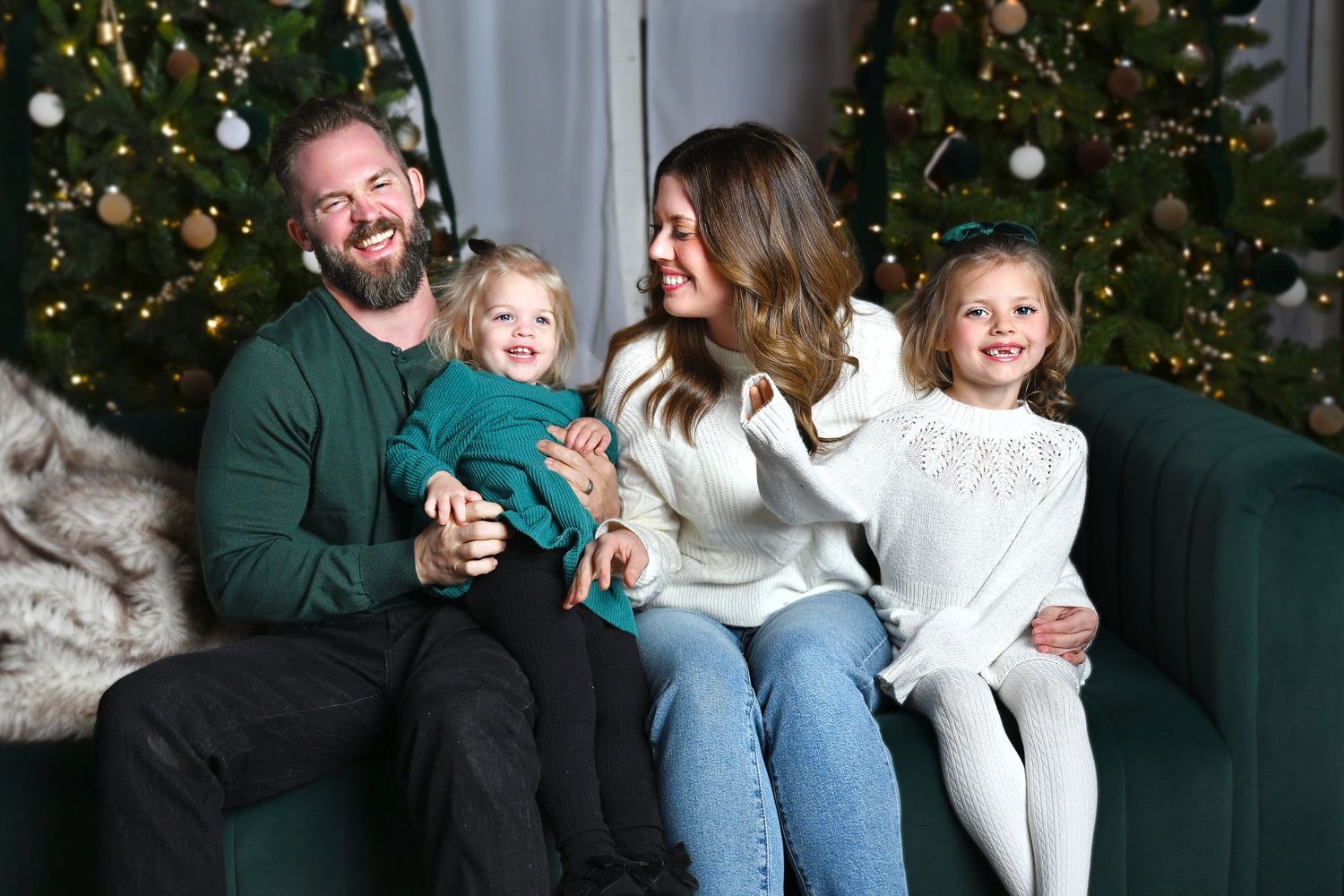 Family of four laughing together during a studio shoot.