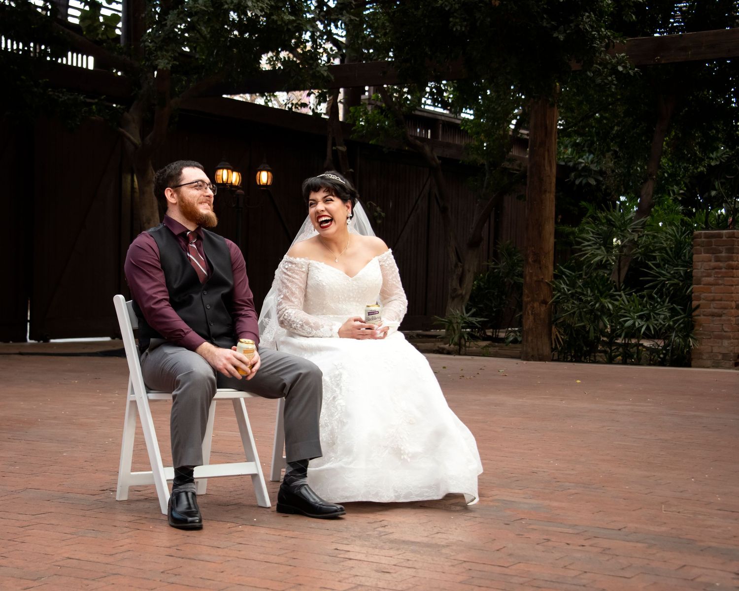 Candid wedding photo of bride and groom sitting and laughing in Downtown Phoenix Melrose District