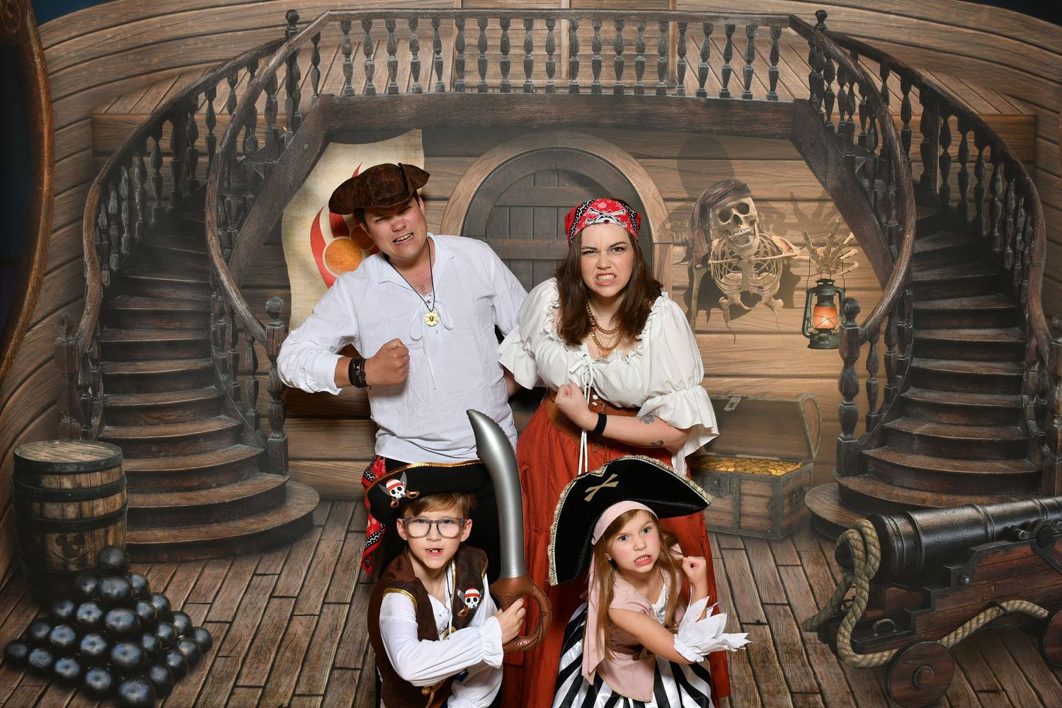 Family of four wearing pirate costumes on a ship