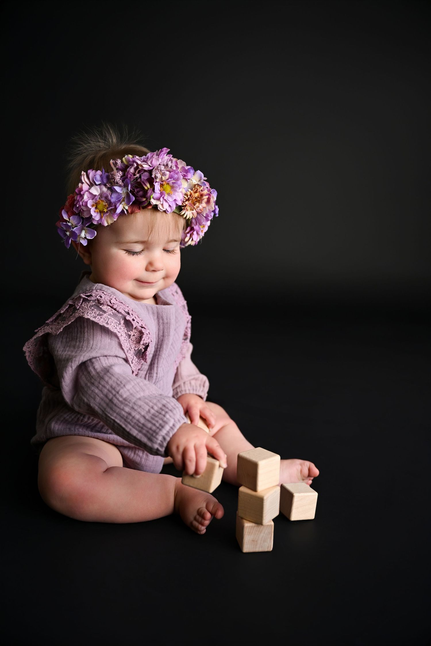 Baby building with blocks happily in candid image on black background 10 month old MIlestone photos in Arizona