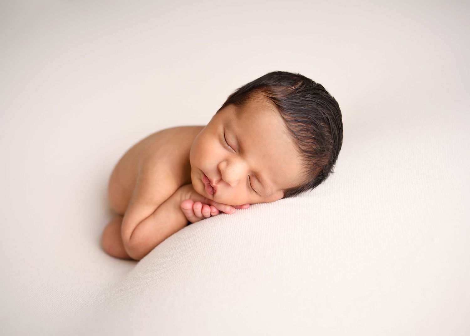 Simply white newborn photo of baby boy in taco pose in Phoenix Arizona Photography studio