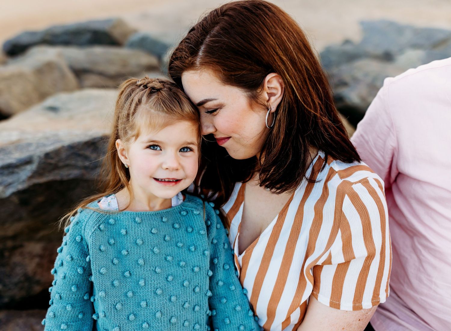 Mother nuzzles little girl in blue sweater in Mommy and Me photo
