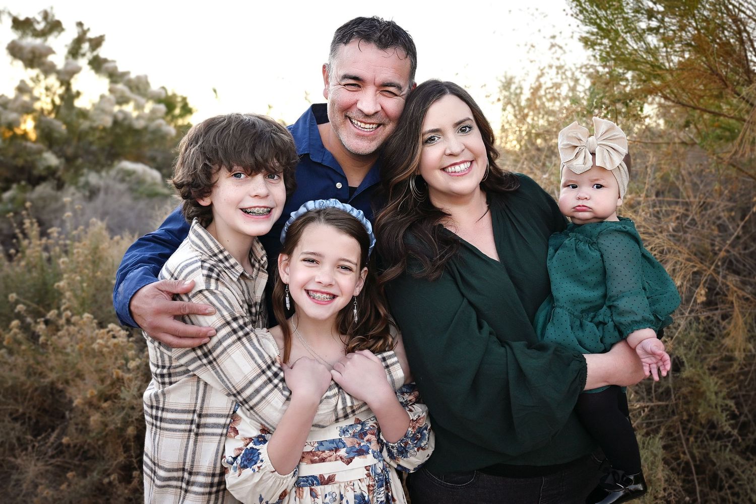 Family of five smiling in front of a Gilbert Arizona Field.