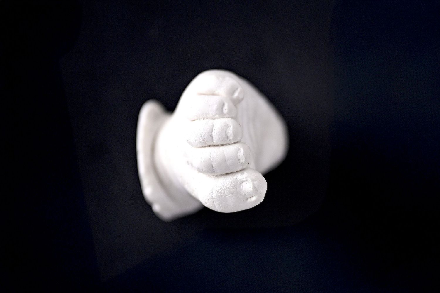 A concrete casting of a newborn baby's foot looking at the fine details of the little toys. a Handmade keepsake heirloom art piece
