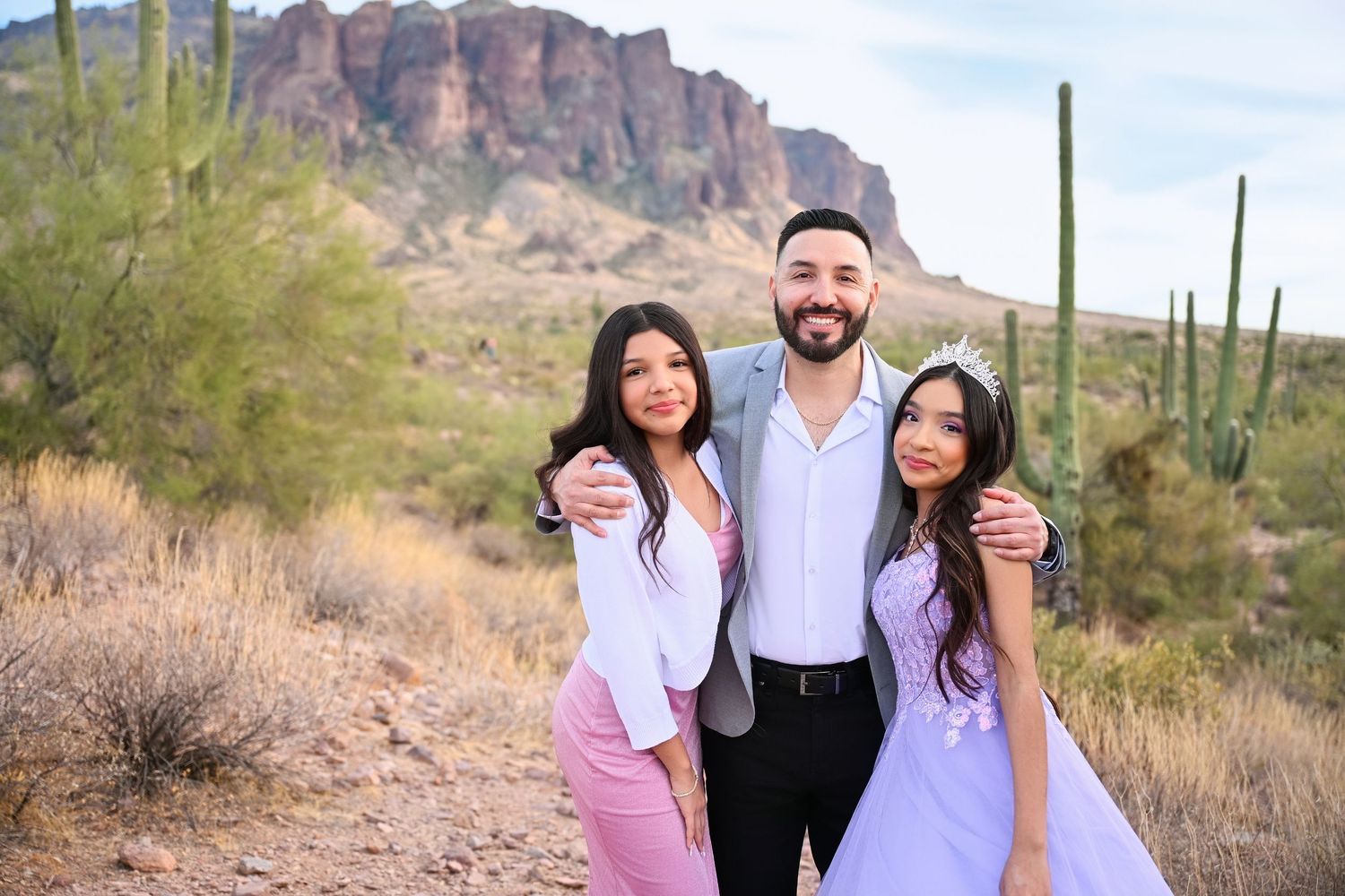 Father holds his teenage daughters close in Arizona Desert Phoenix Birthday quinceañera session