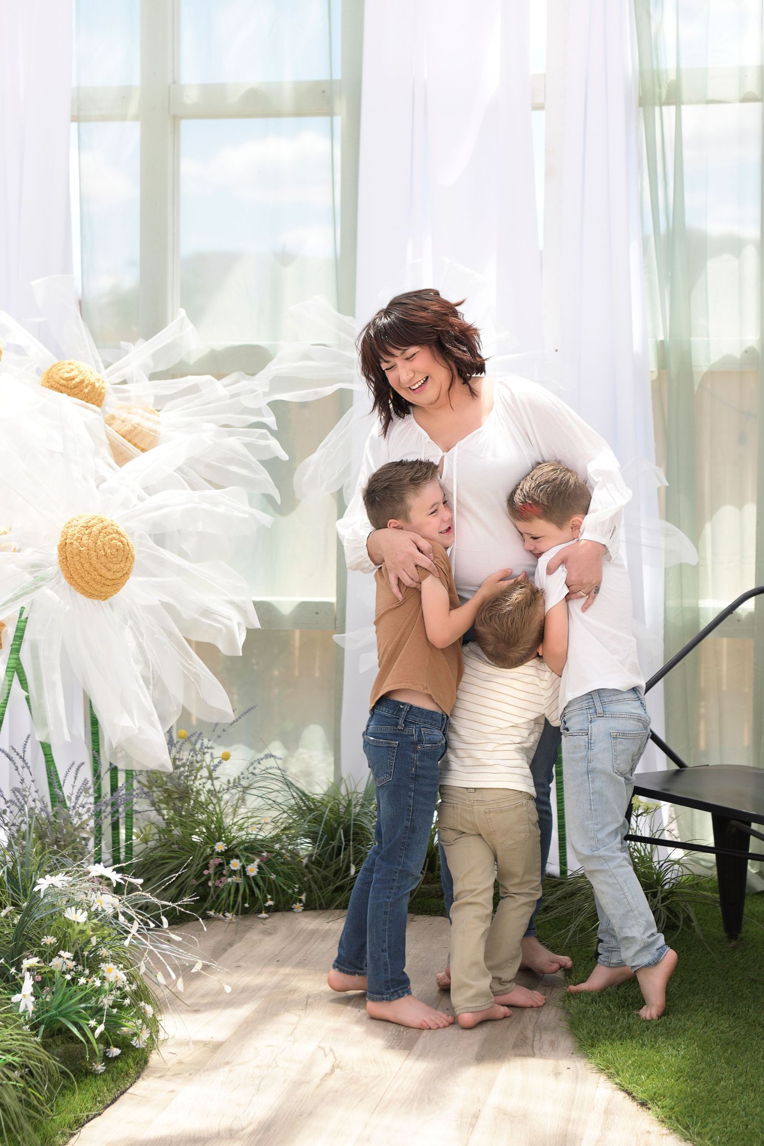Mom and Siblings hugging in a colorful outdoor setting.