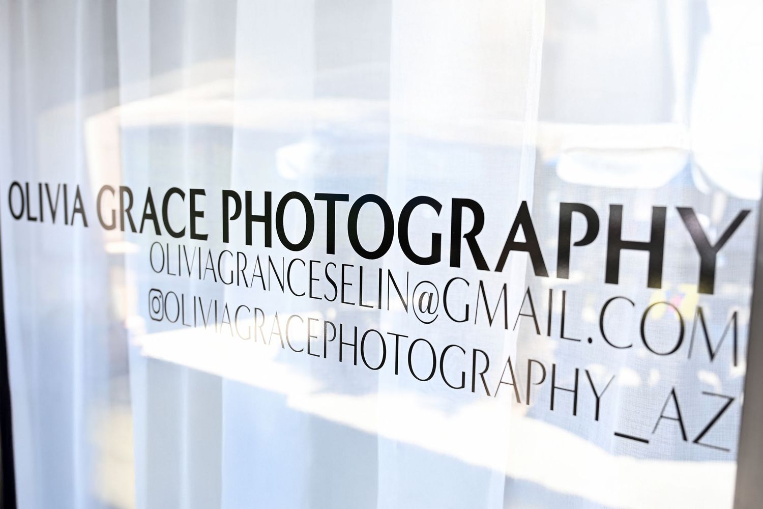 Sign on Phoenix photography studio window that lists Olivia Grace Photography and the website url