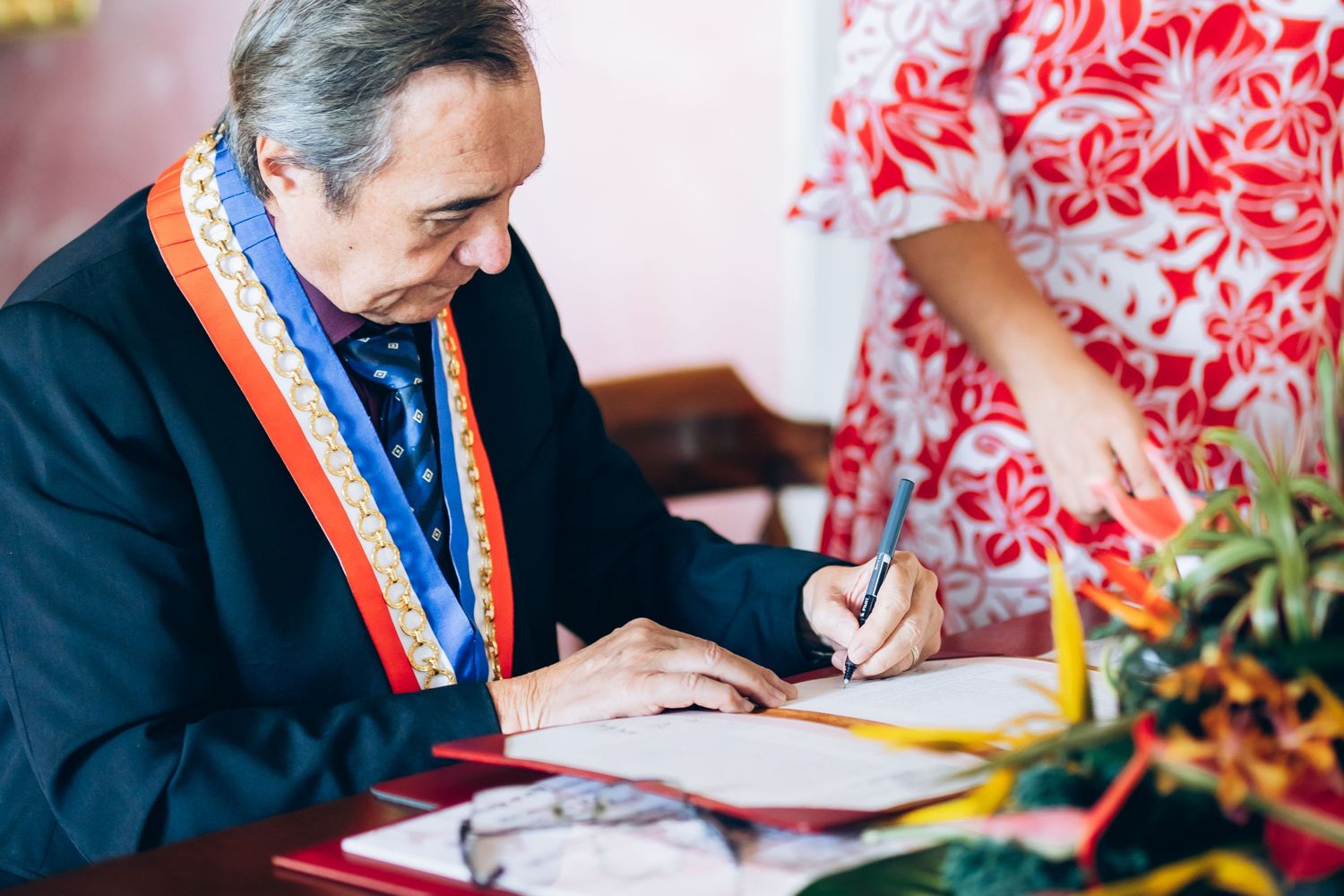 Le maire officiel portant des signes de mariage colorés lors d'une cérémonie de mariage formelle.