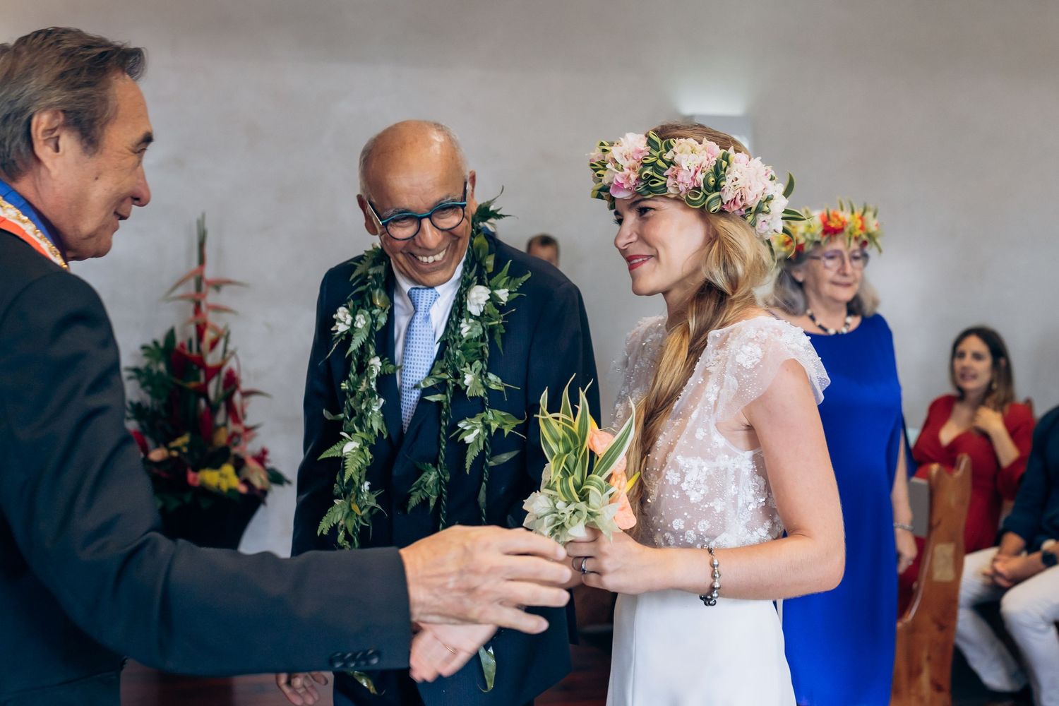 La mariée en couronne florale échange des vœux avec le marié lors d'une cérémonie tropicale intime.