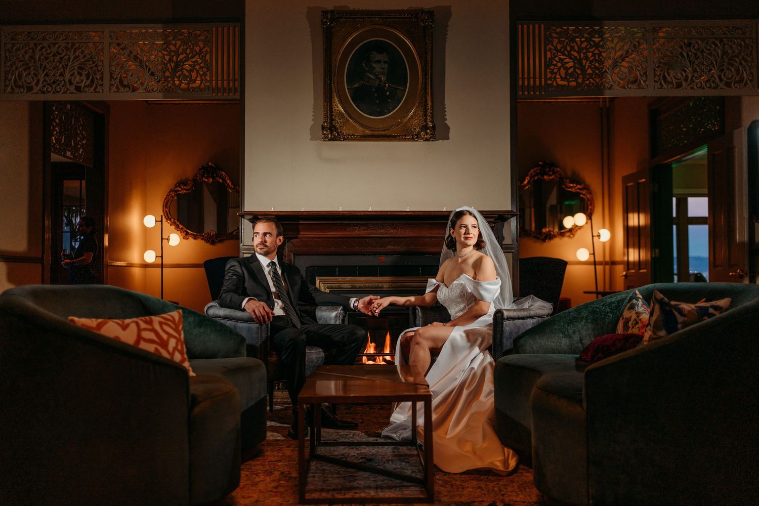 Wedding couple seated in elegant vintage room with warm lighting and ornate decor. San Francisco, California.