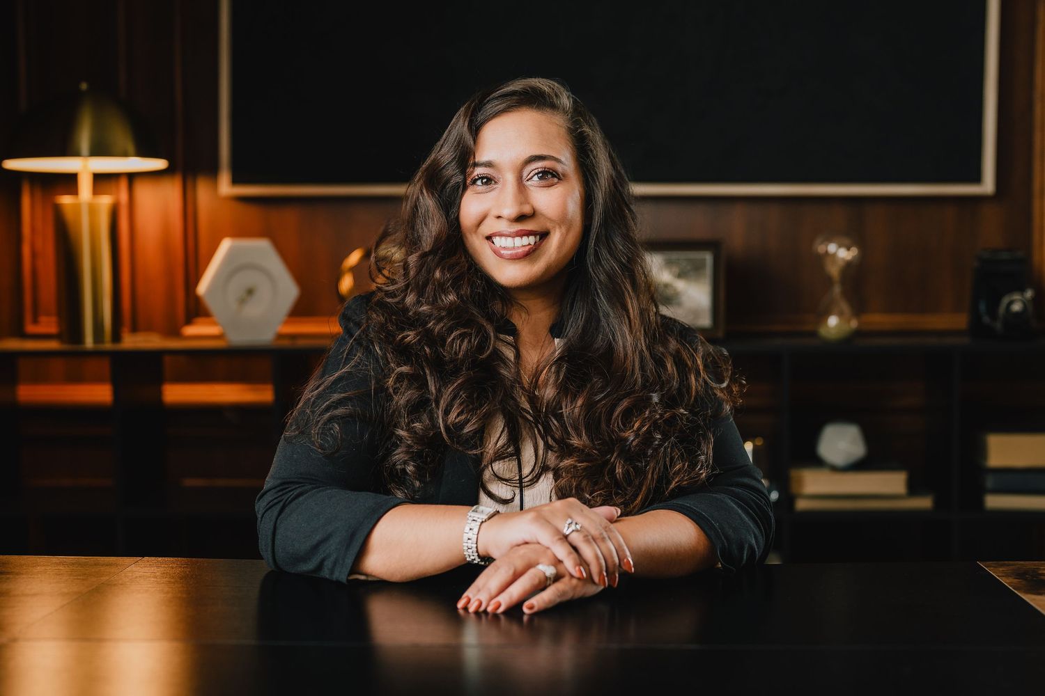 Warm corporate portrait of someone at desk with bookshelves and office decor in background. Nashville, Tennessee.