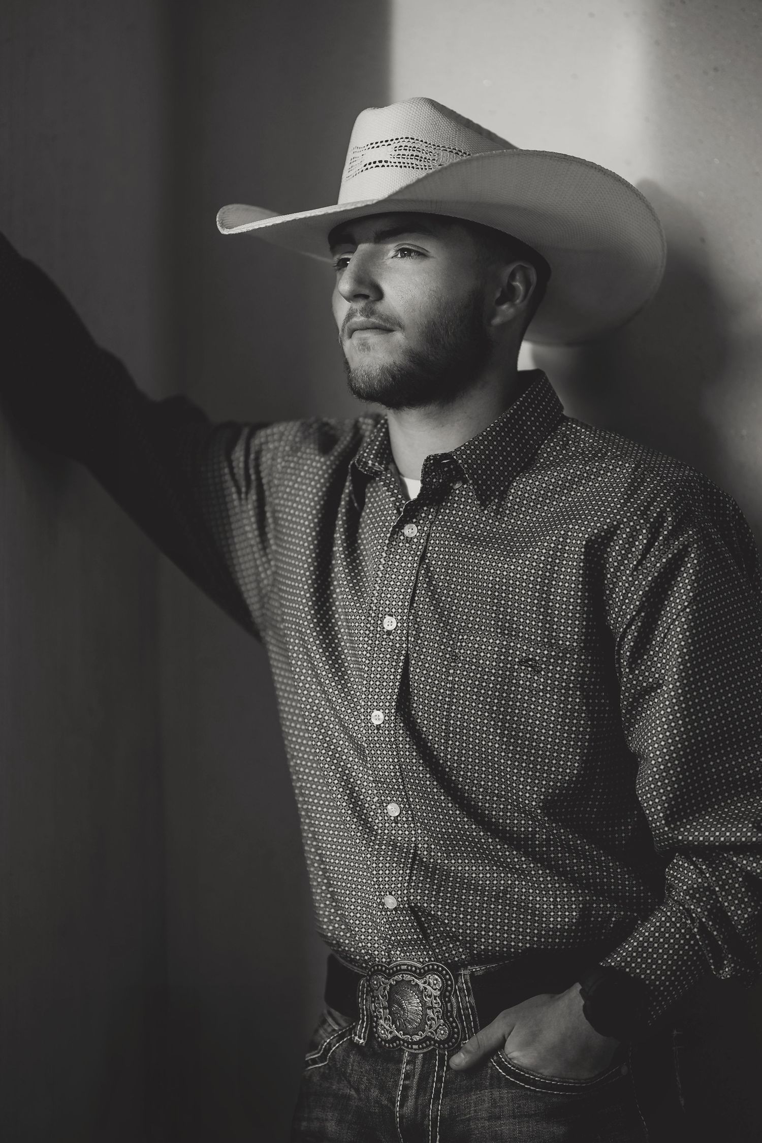 A dramatic black and white portrait of someone in western attire and cowboy hat looking to the side. Murfreesboro, Tennessee.