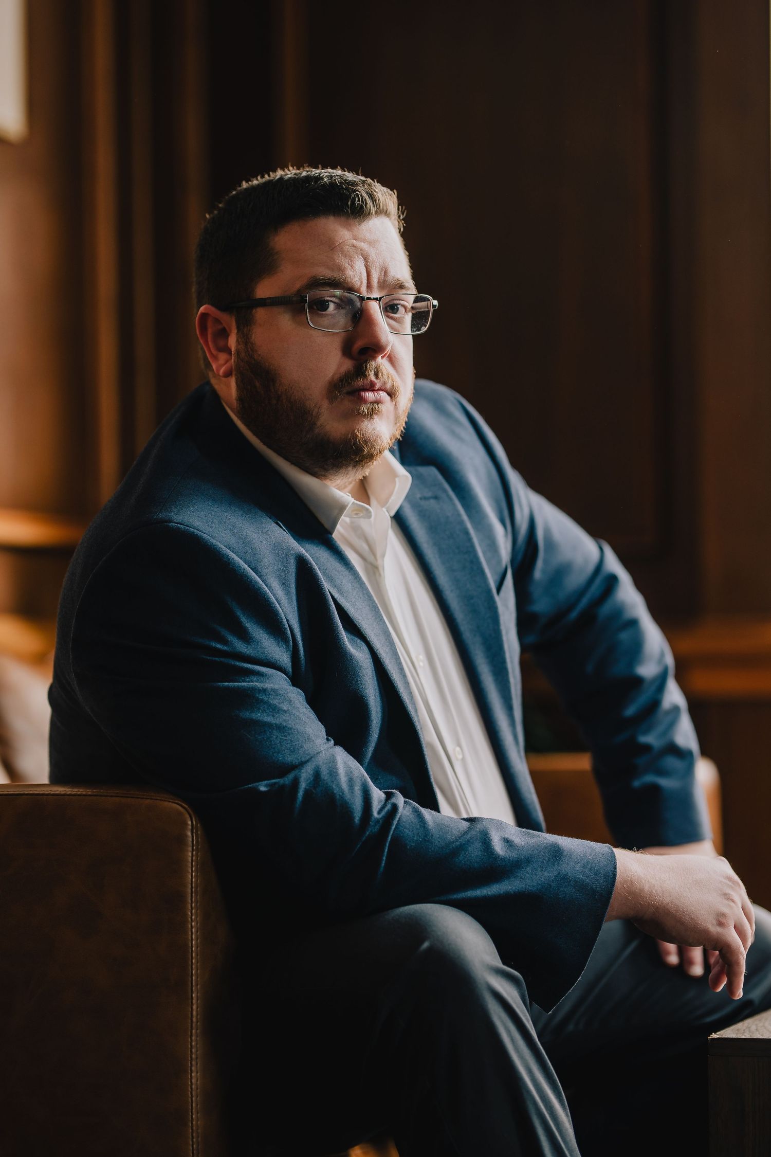 Professional portrait of person in suit jacket seated in warm-lit environment. Nashville, Tennessee.
