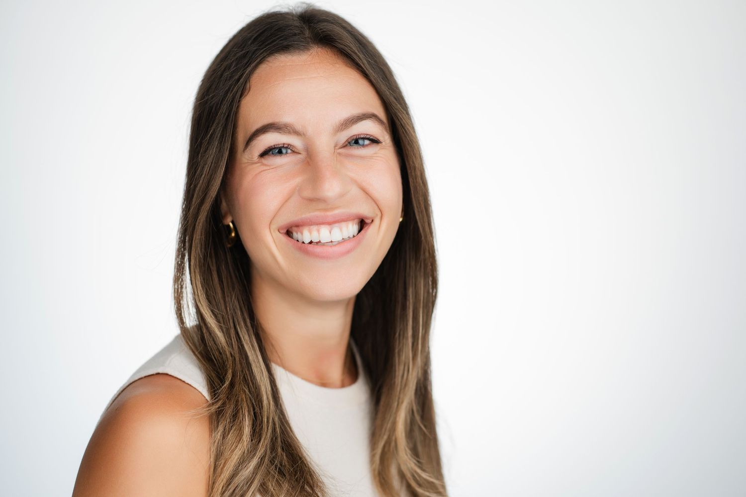 Studio portrait of person in white top with natural smile against light background. Nashville, Tennessee.