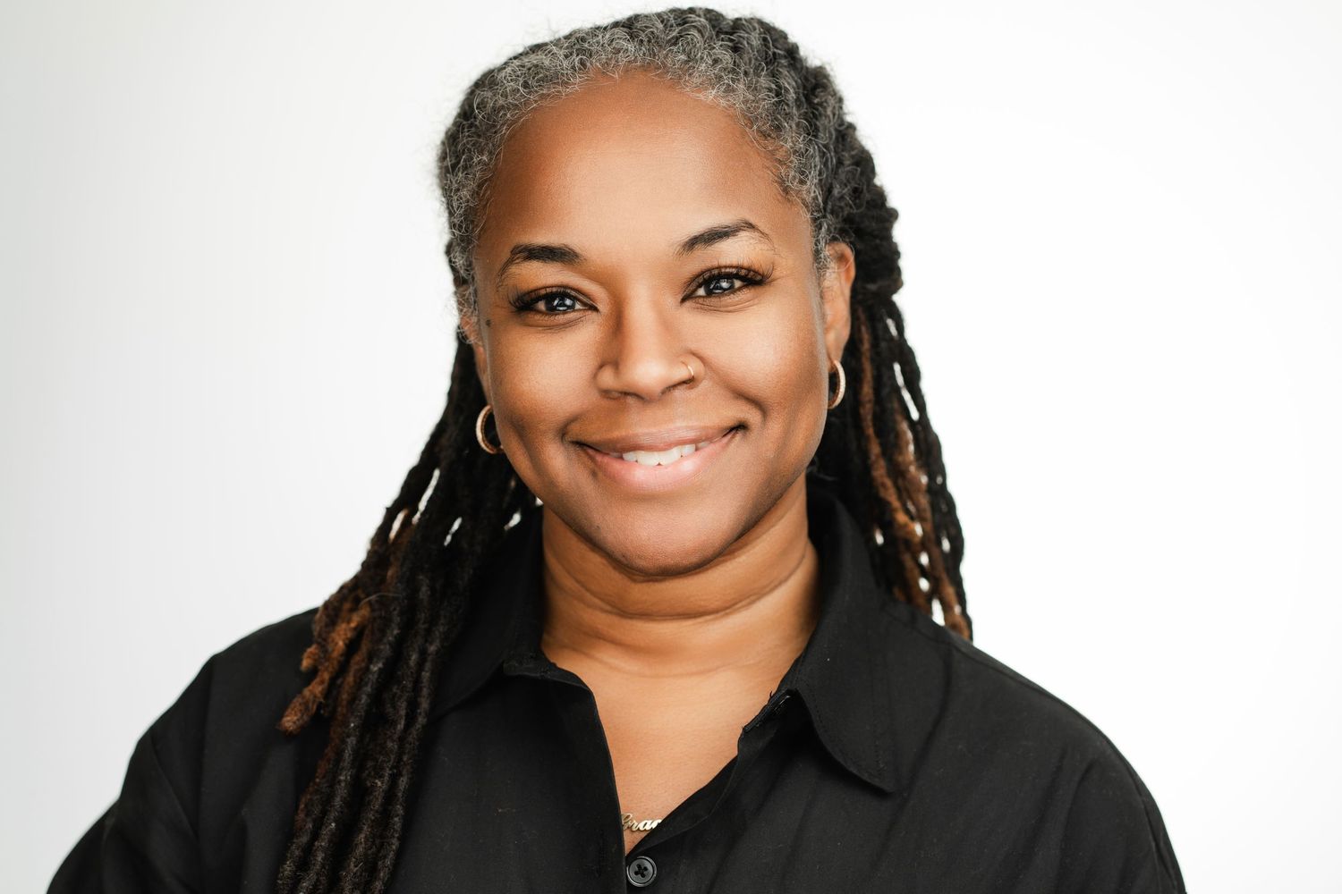 Professional headshot of a person with braided hair wearing a black shirt against a white background. Nashville, Tennessee.