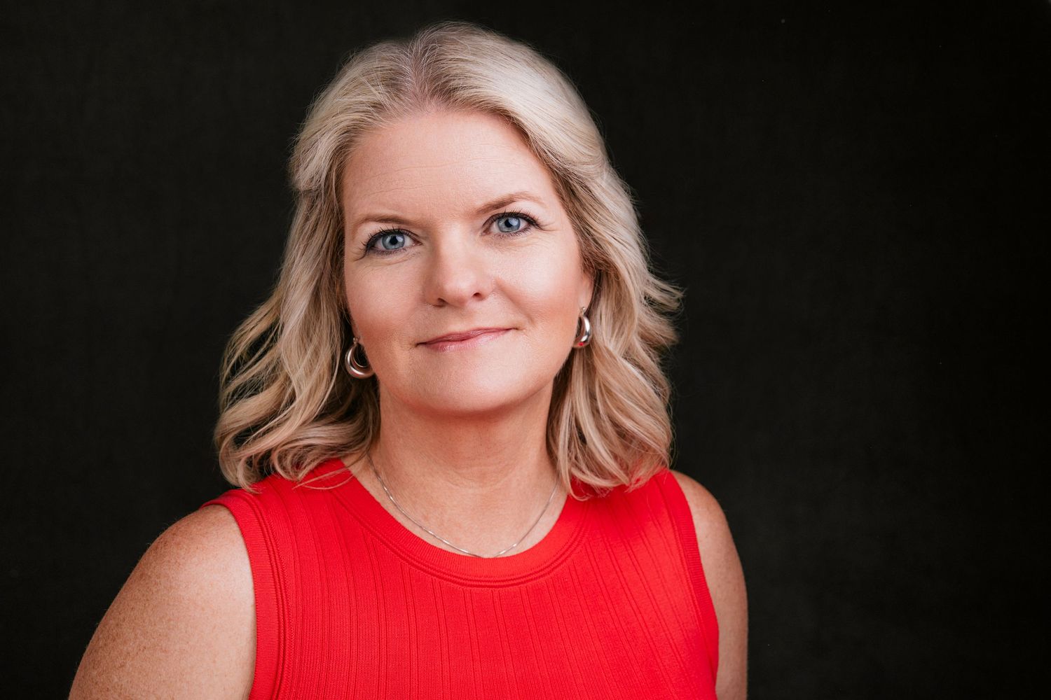 Professional portrait of person in red sleeveless top against dark background. Nashville, Tennessee.