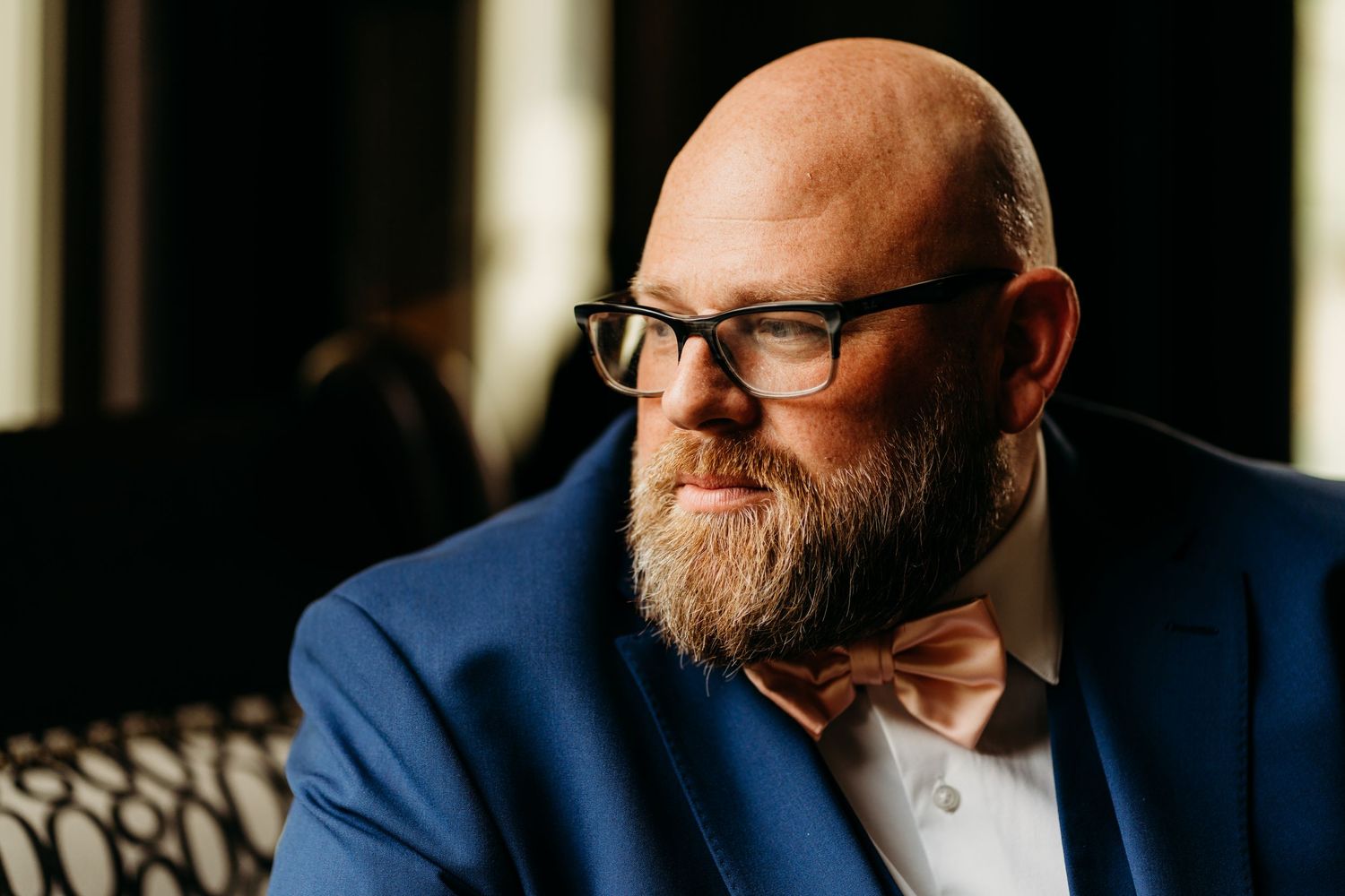 Portrait of man with beard wearing glasses and bow tie in navy blue suit jacket. Legacy Farms, Nashville, Tennessee.