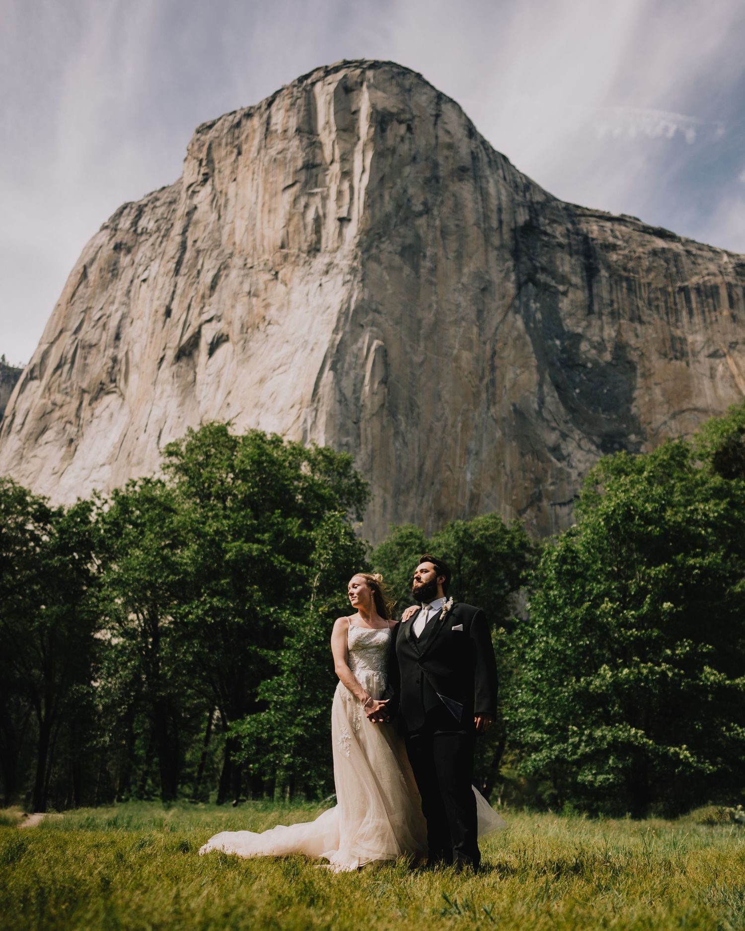 Wedding couple posing in front of El Capitan's towering rock face in Yosemite National Park.