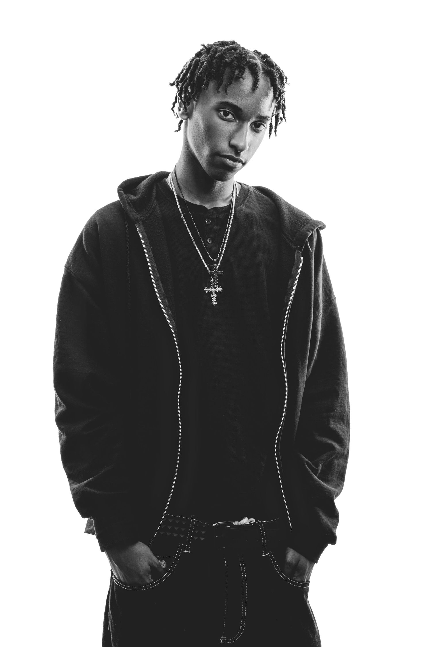 Monochrome studio portrait wearing hoodie and cross necklace against white background. Nashville, Tennessee.