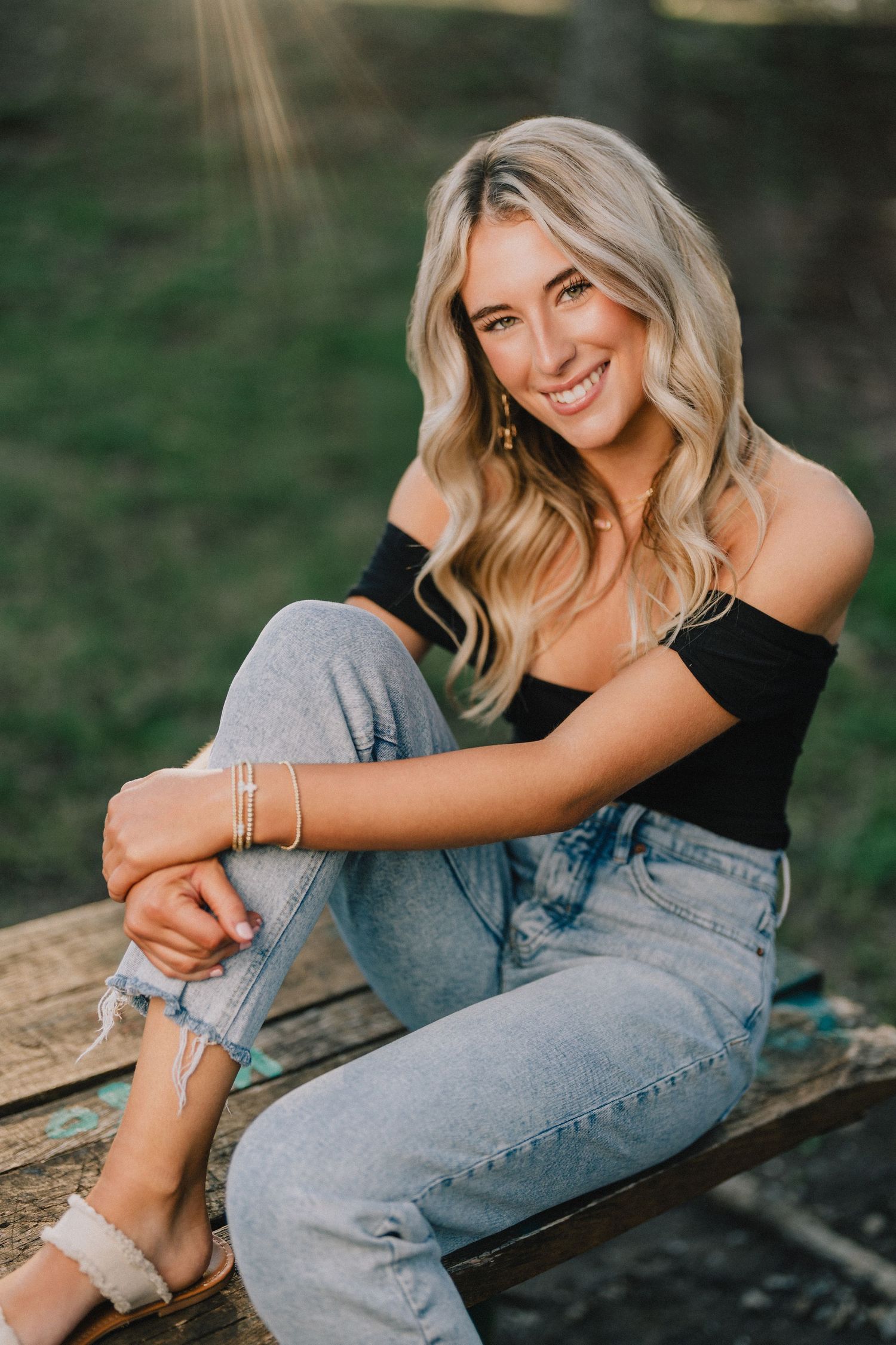 Casual lifestyle portrait wearing off-shoulder top and distressed jeans while sitting outdoors. Murfreesboro, Tennessee.