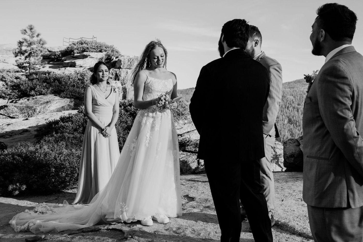 Outdoor wedding ceremony with couple and guests gathered on scenic mountain overlook. Yosemite national Park, California.
