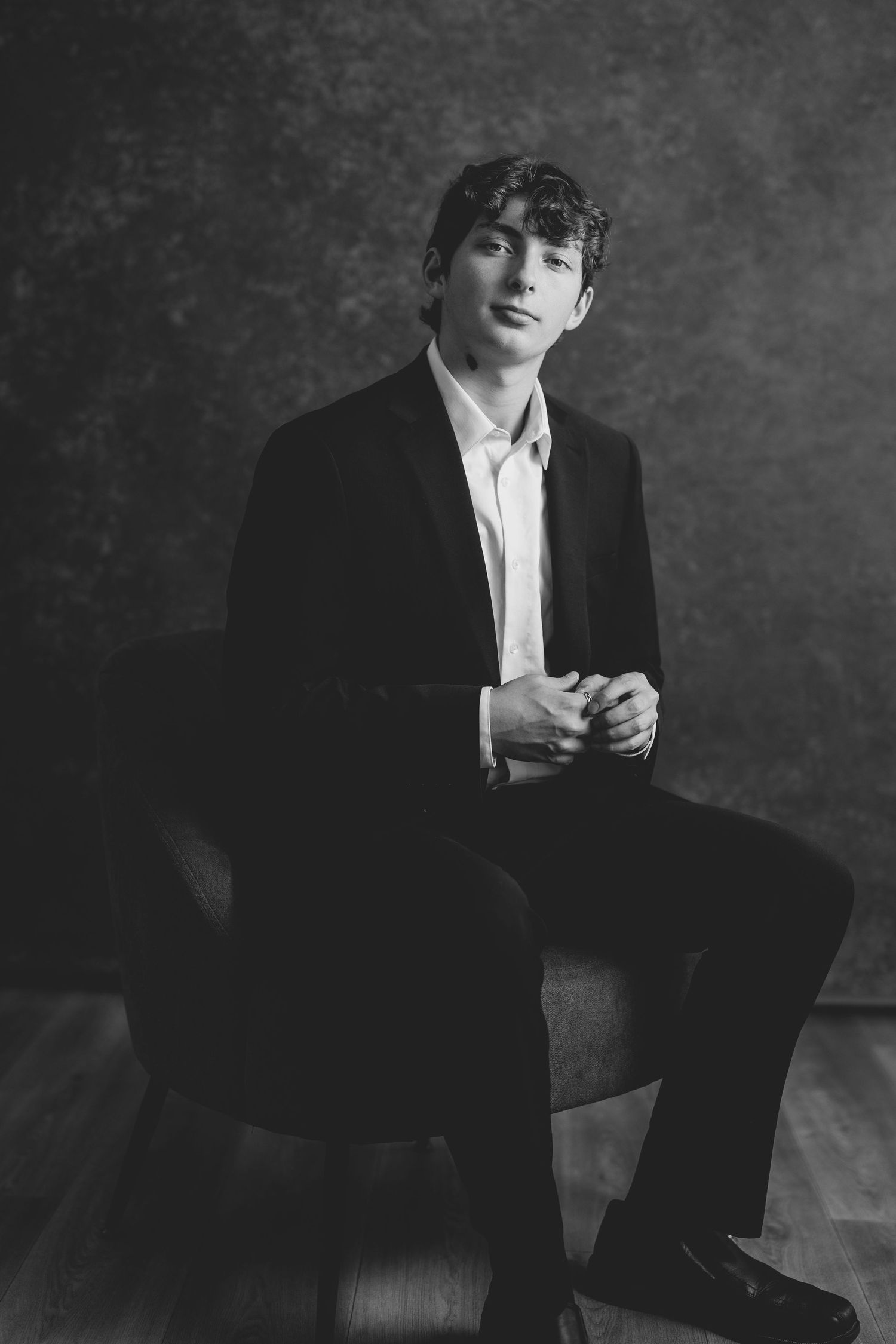 Classic black and white portrait of someone in formal attire seated against textured backdrop. Nashville, Tennessee.