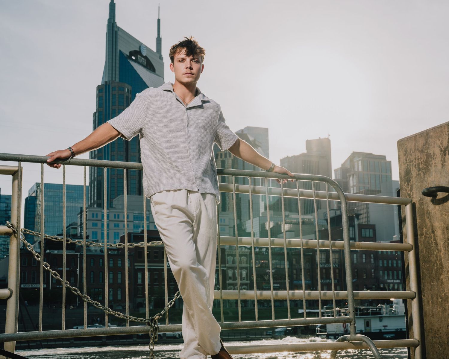A casual figure poses on an urban rooftop with modern city buildings in the background. Murfreesboro, Tennessee.