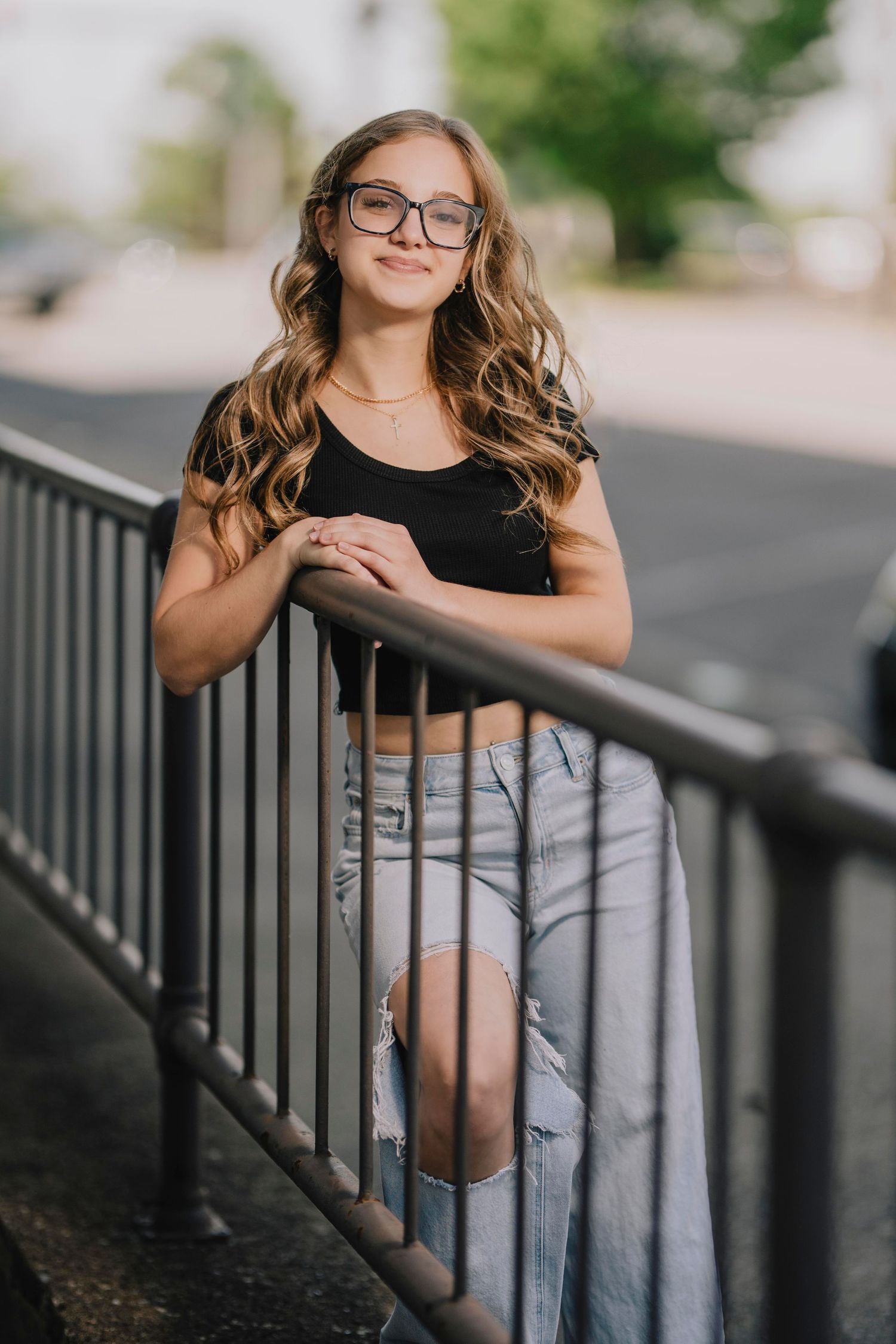 A portrait of someone in casual attire leaning on a metal railing outdoors. Murfreesboro, Tennessee.