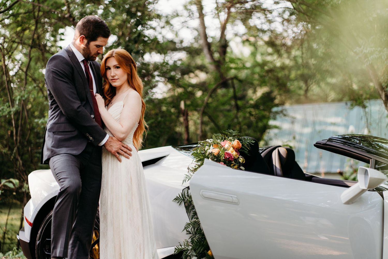 Romantic couple poses with vintage white convertible car during wedding photoshoot. Nashville, Tennessee.