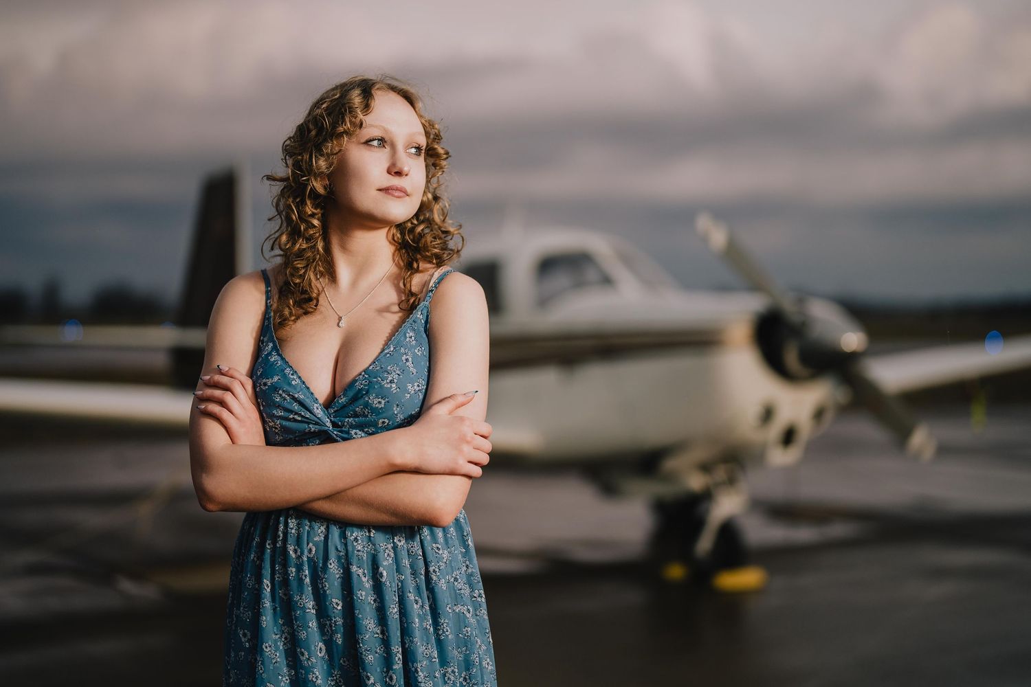 Portrait in blue dress standing near a small aircraft at dusk. Murfreesboro, Tennessee.