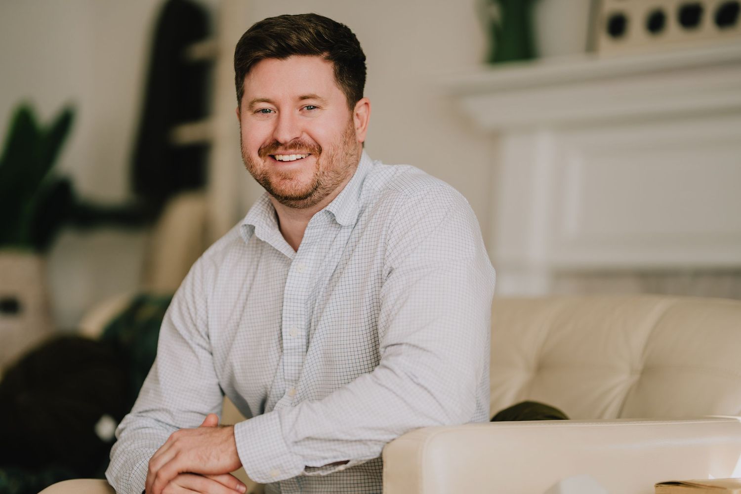 Professional portrait of person in light shirt seated on cream colored couch. Nashville, Tennessee.