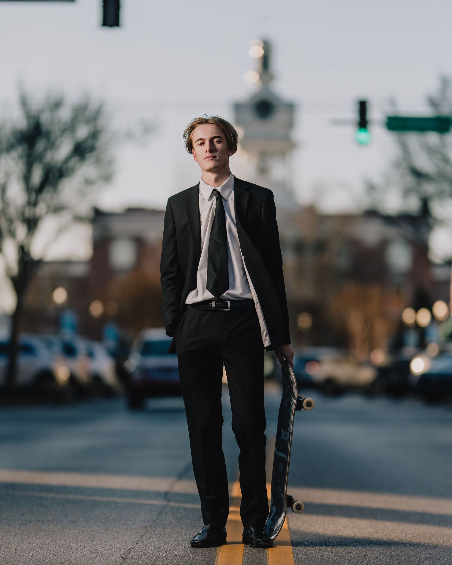 Urban street portrait with skateboard against city backdrop featuring historic clocktower. Nashville, Tennessee.