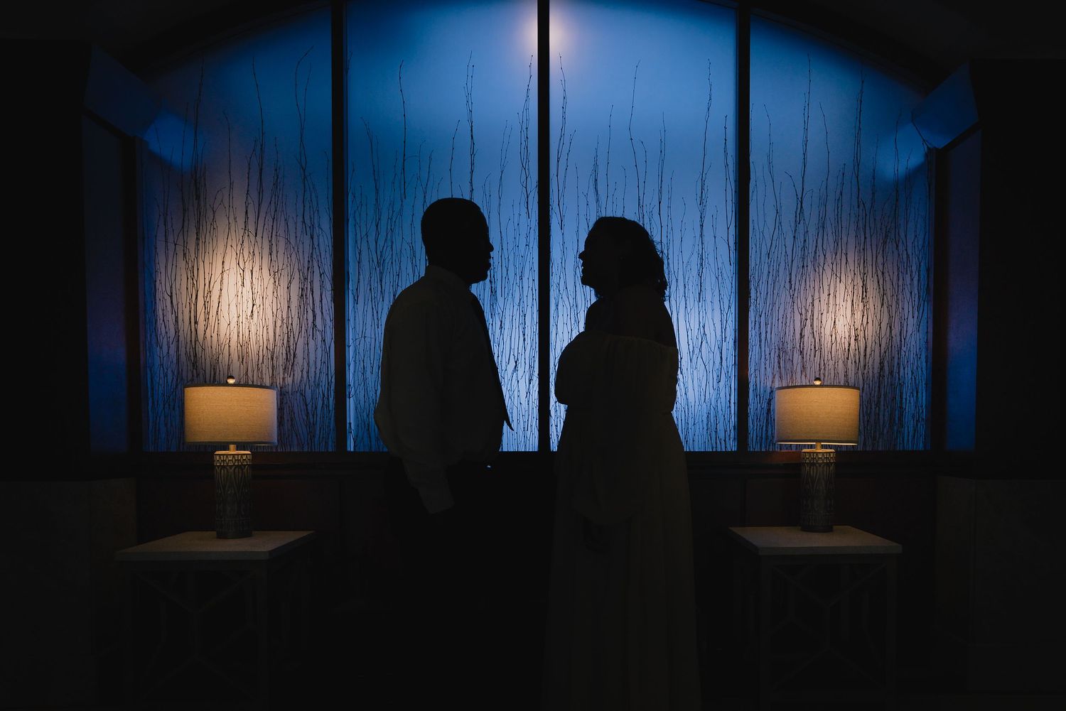Romantic silhouette of couple against blue backlit curtains with candlelight. Nashville, Tennessee.