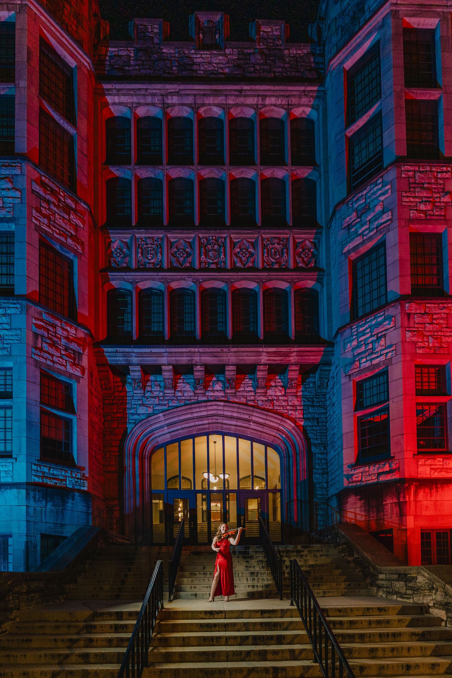 Dramatic architectural scene with red and blue lighting on a gothic building entrance featuring stone steps and archways. Nashville, Tenness